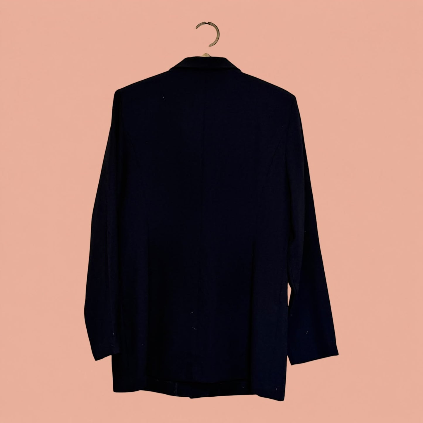 Blazer negro de segunda mano de Tuclosetrenovado.cl visto desde la parte trasera colgado en una percha