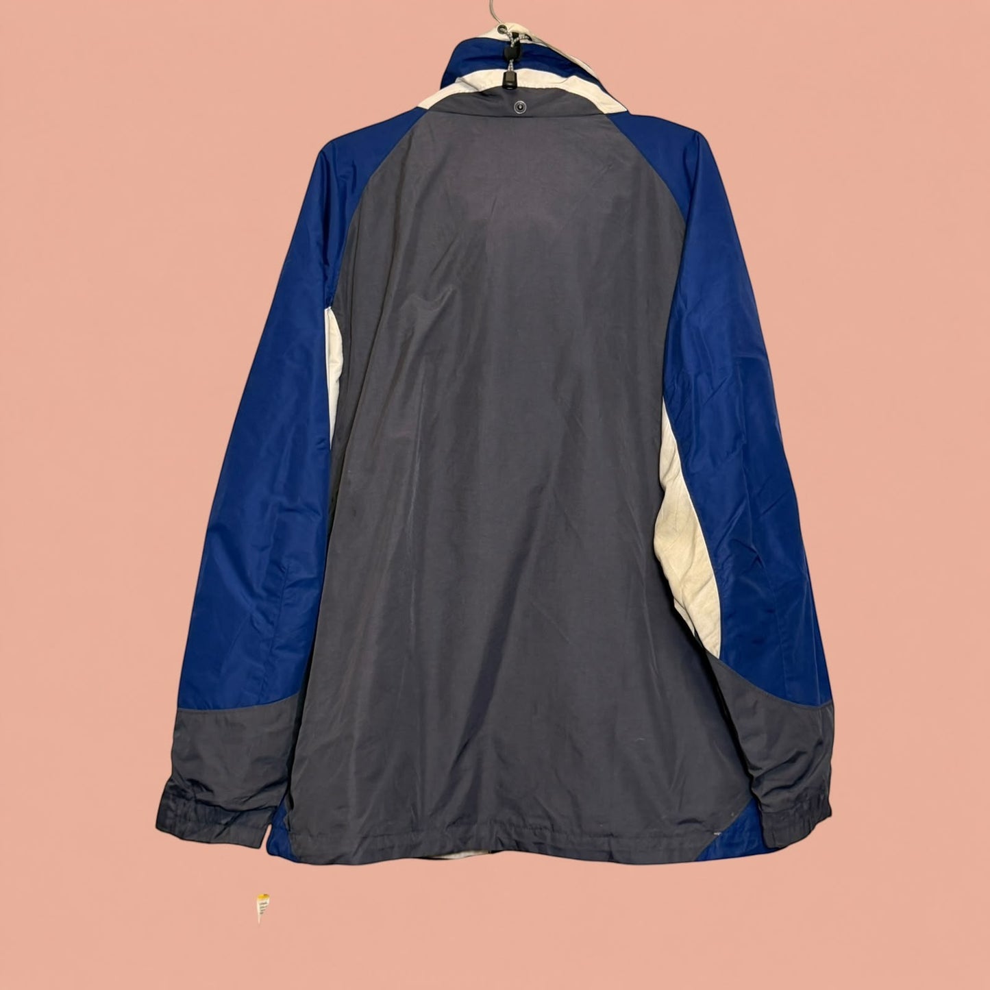 Chaqueta cortavientos Tuclosetrenovado.cl de hombre en azul y gris, diseño deportivo con cierre y cuello alto