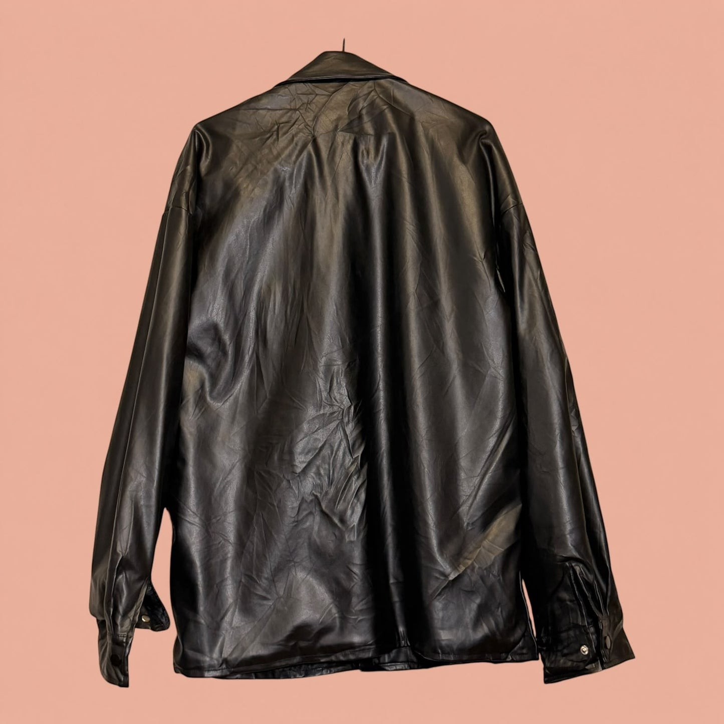 Chaqueta de eco cuero negra de segunda mano de Tuclosetrenovado.cl vista trasera con acabado brillante