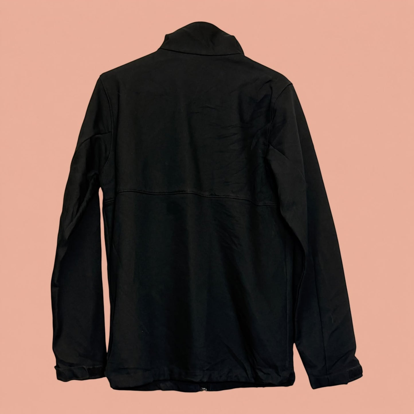 Chaqueta negra de hombre Tuclosetrenovado.cl, diseño técnico con cuello alto, vista trasera sobre fondo salmón