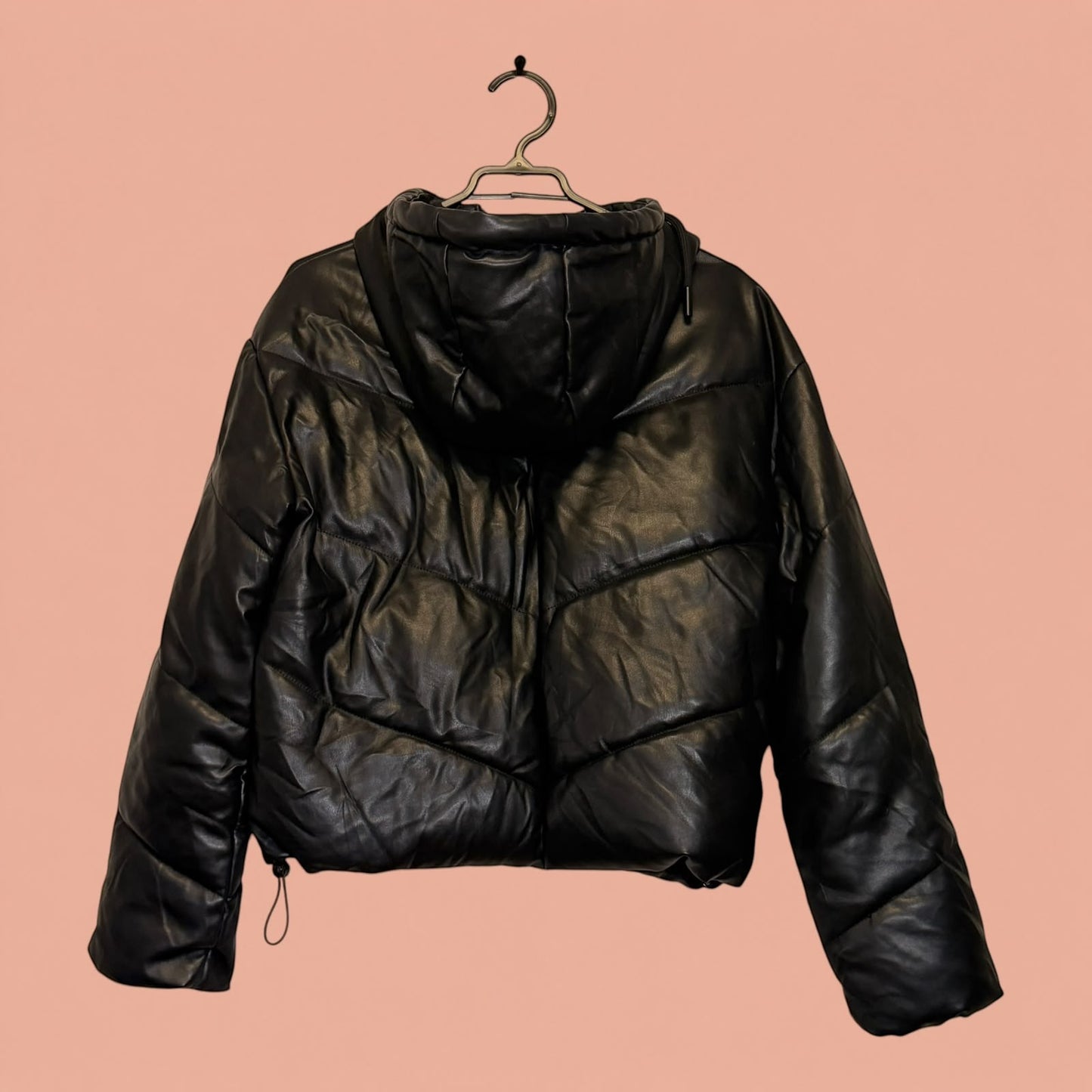 Chaqueta acolchada negra de eco cuero con capucha de Tuclosetrenovado.cl, estilo puffer de segunda mano.