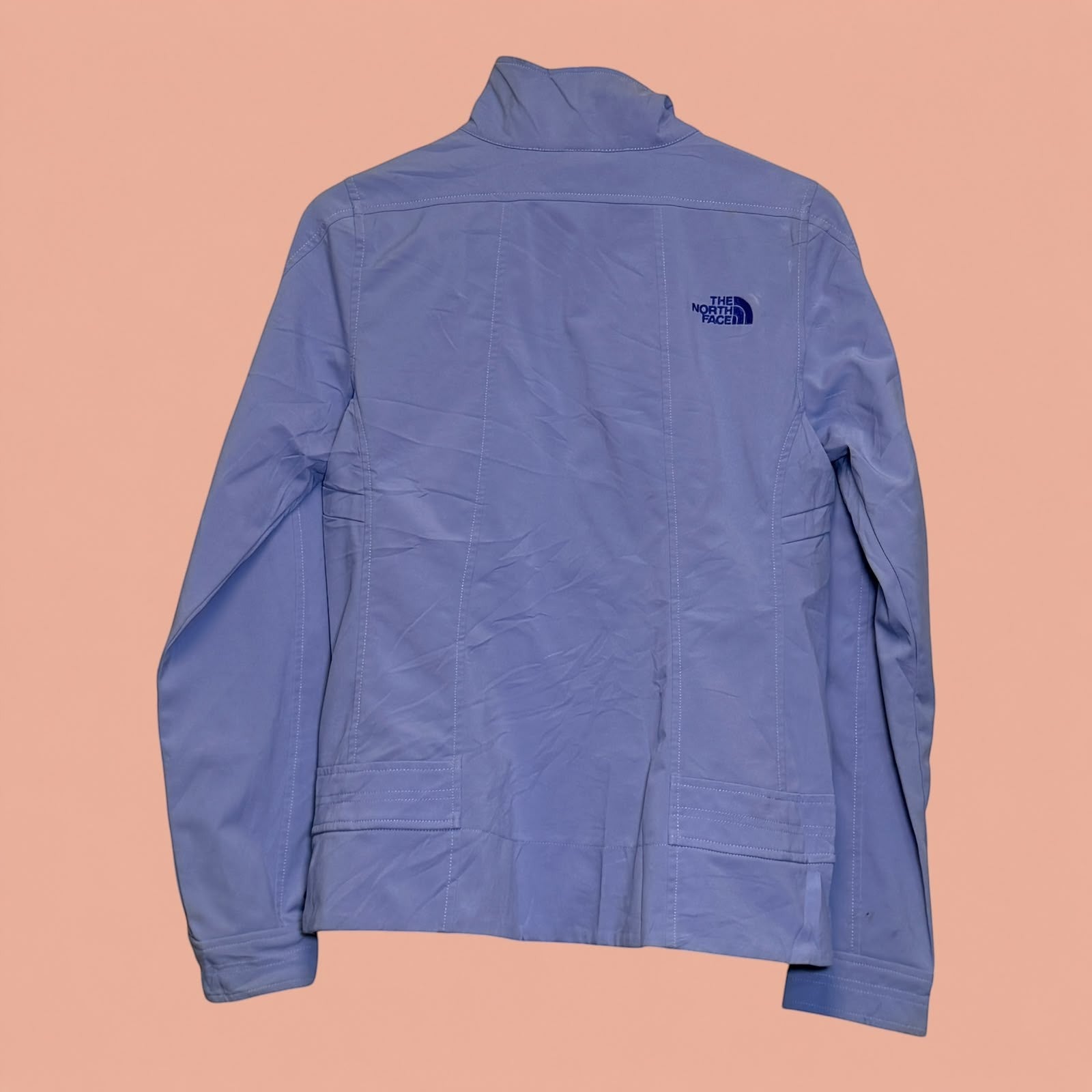 Chaqueta ligera azul claro de The North Face vista trasera, disponible en Tuclosetrenovado.cl