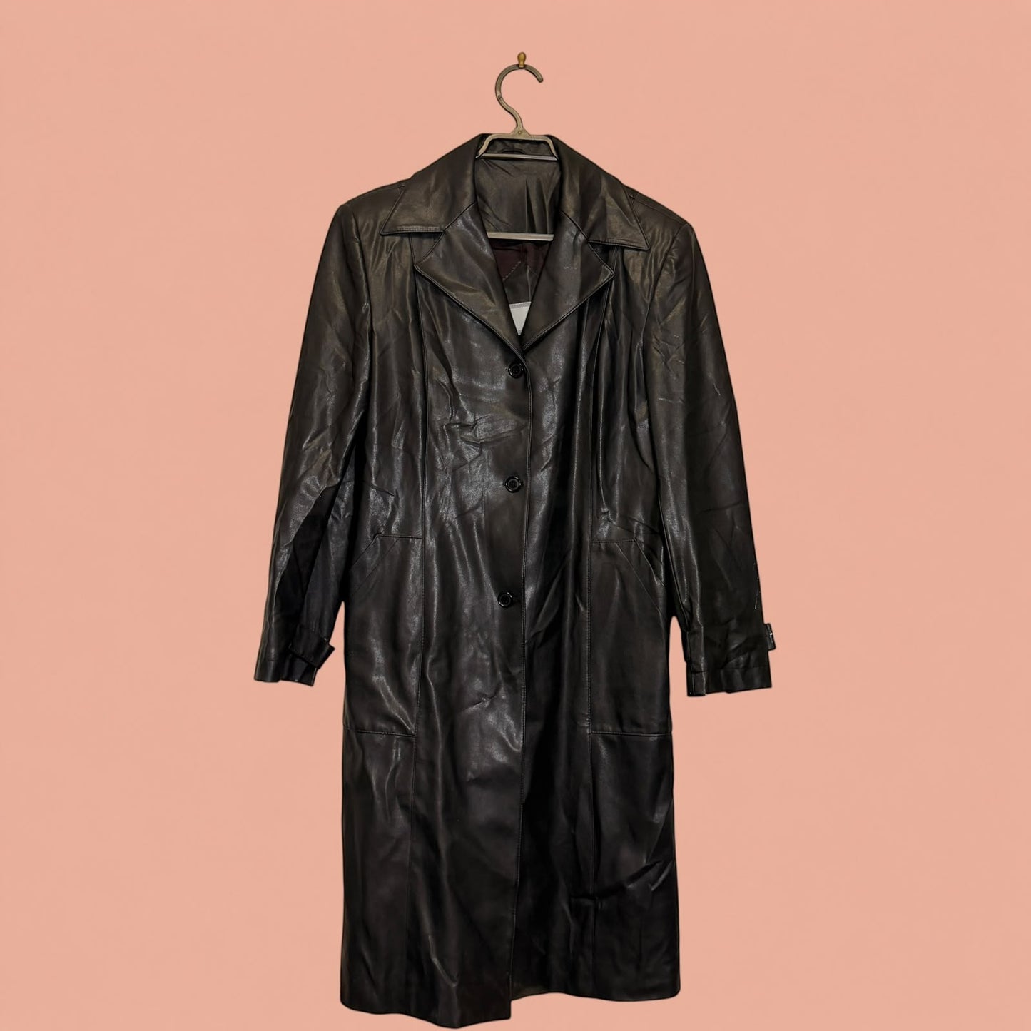Abrigo largo de eco cuero negro de Tuclosetrenovado.cl con botones frontales y cuello clásico