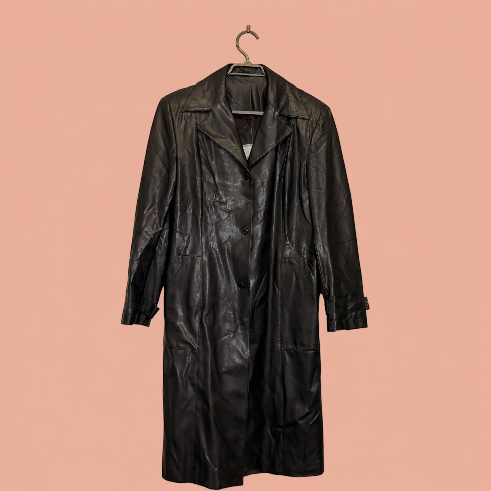 Abrigo largo de eco cuero negro de Tuclosetrenovado.cl con botones frontales y cuello clásico