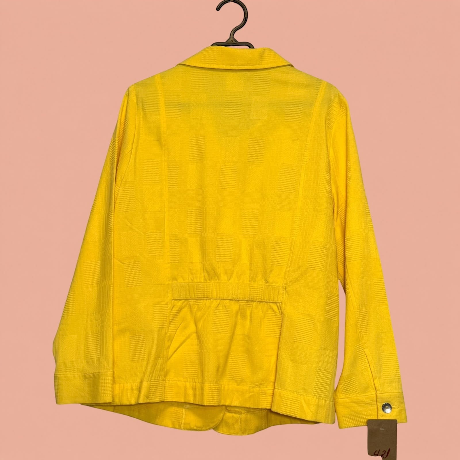Blazer amarillo de segunda mano con textura geométrica de Tuclosetrenovado.cl, vista trasera en percha