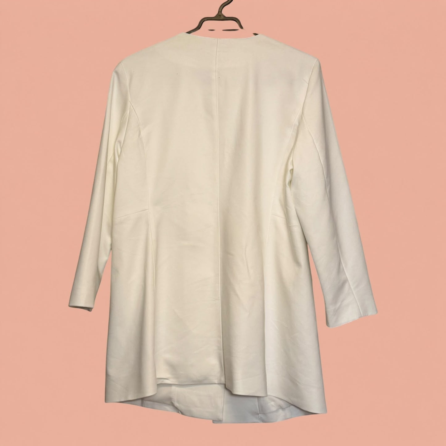 Blazer blanco de segunda mano de Tuclosetrenovado.cl, diseño minimalista sin cuello y corte entallado.