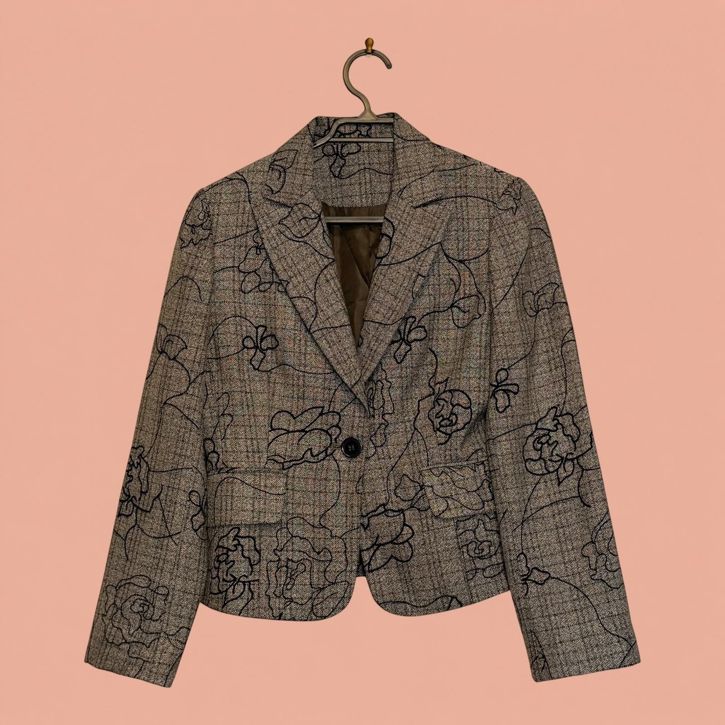 Blazer de segunda mano Tuclosetrenovado.cl gris con estampado floral negro, corte entallado y cierre de un botón.
