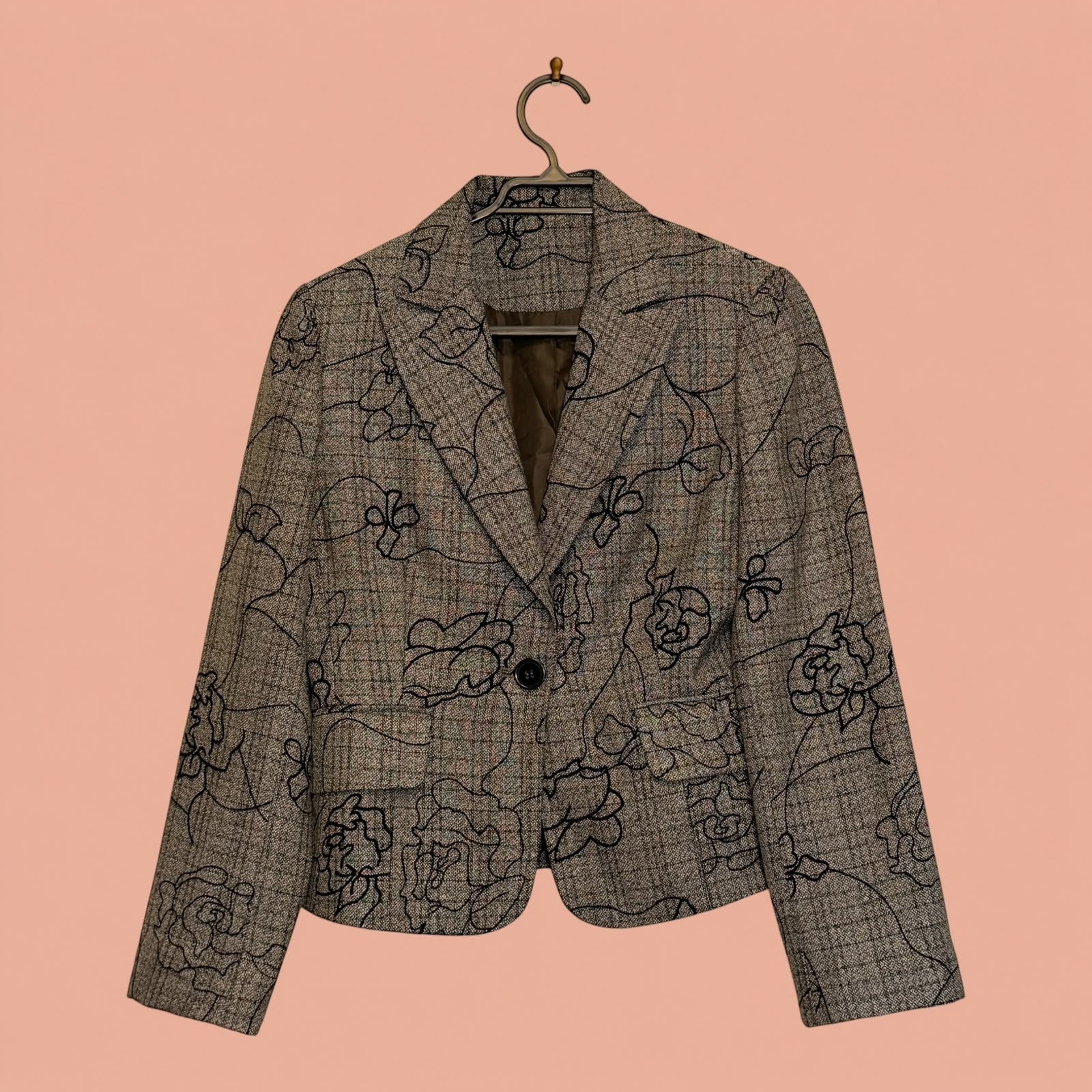 Blazer de segunda mano Tuclosetrenovado.cl gris con estampado floral negro, corte entallado y cierre de un botón.
