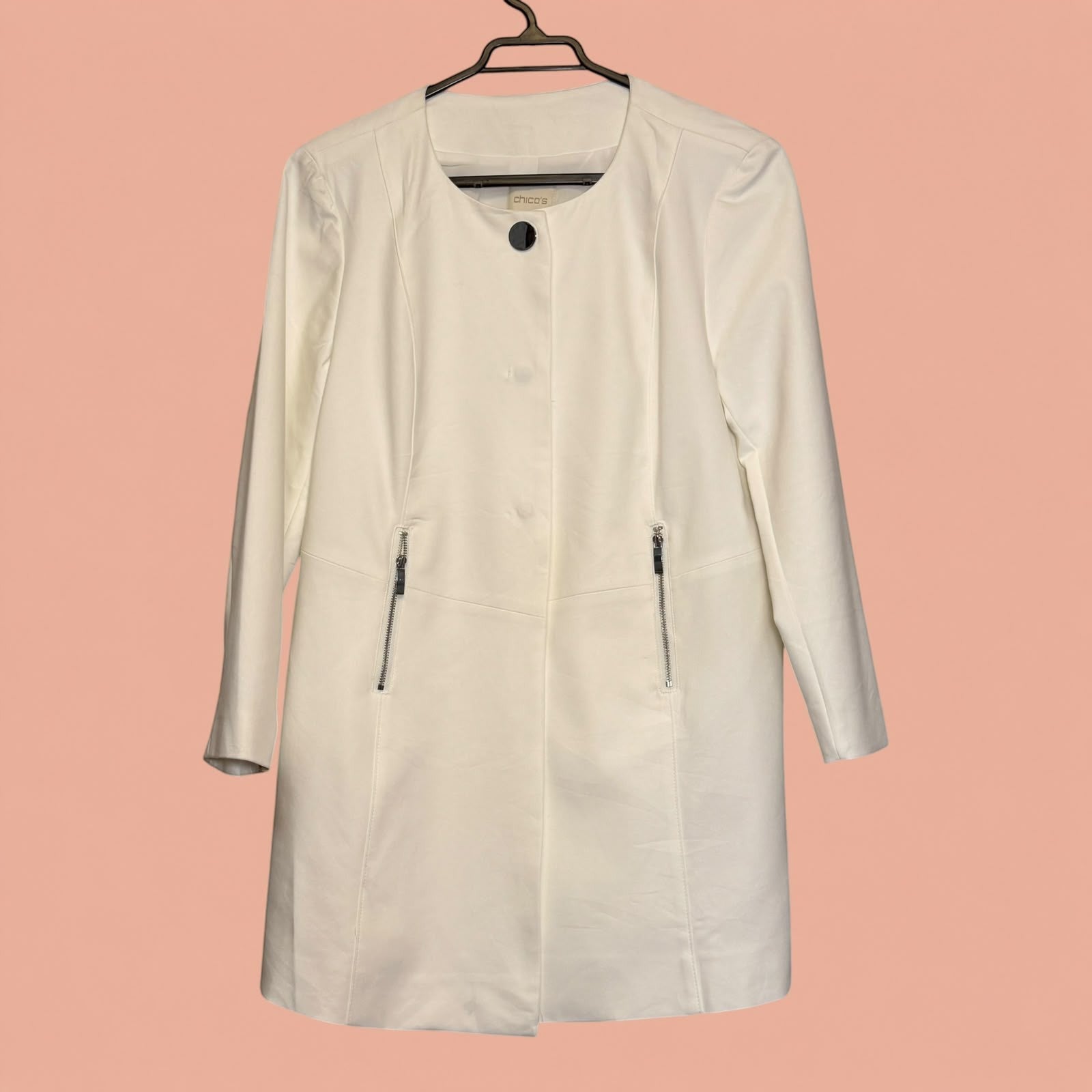 Blazer largo color crema de Tuclosetrenovado.cl con cierre frontal, cuello redondo y bolsillos con cremallera