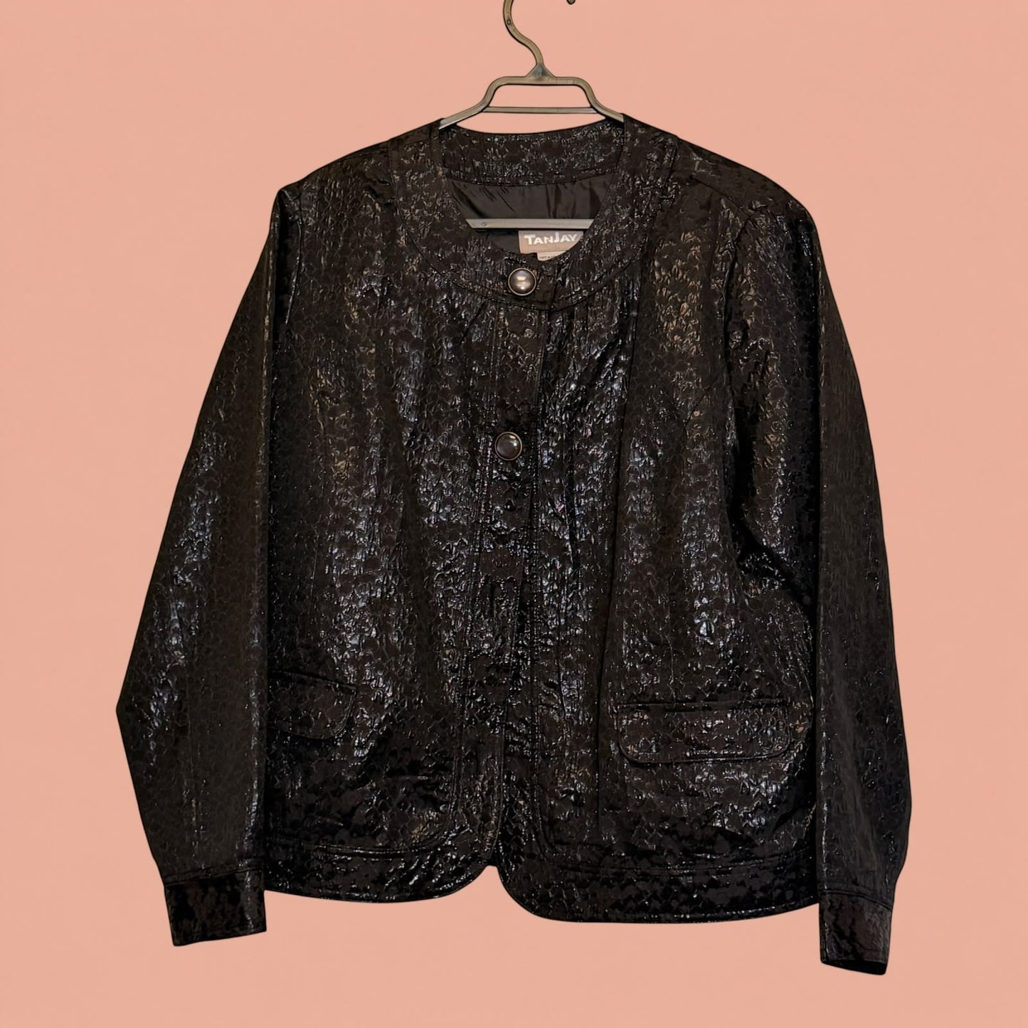 Blazer negro de segunda mano de Tuclosetrenovado.cl con textura brillante y cierre frontal de botones