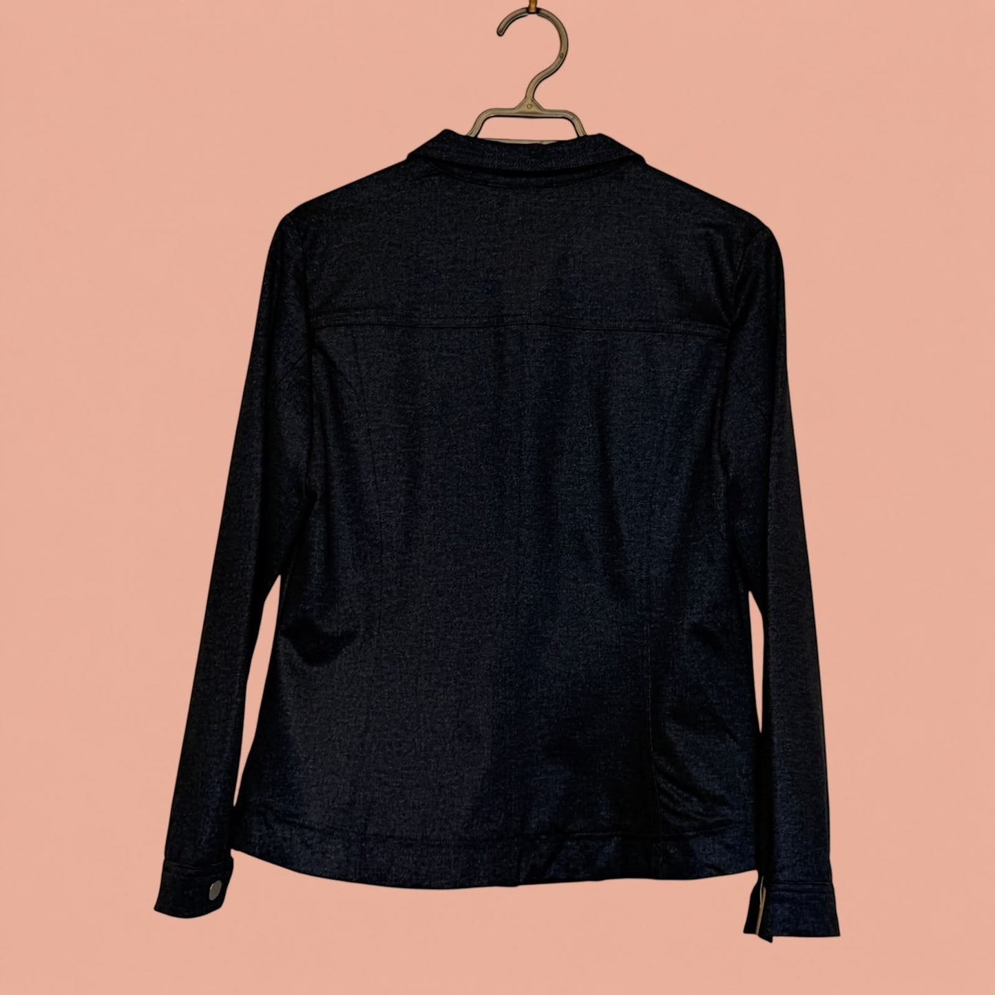Blazer negro de segunda mano de Tuclosetrenovado.cl visto desde la parte trasera sobre fondo rosado