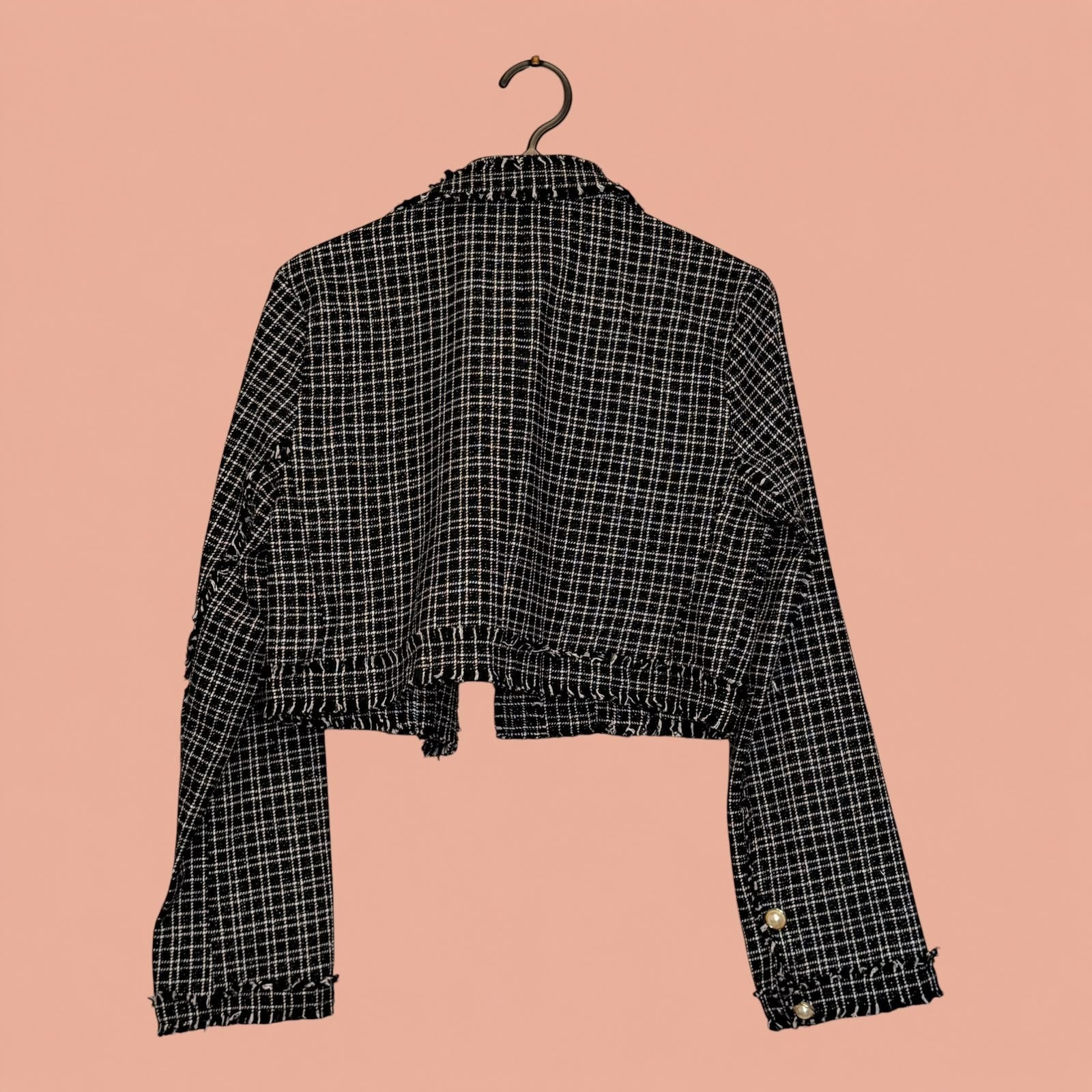 Blazer corto de tweed a cuadros blanco y negro de Tuclosetrenovado.cl con detalles de botones en las mangas