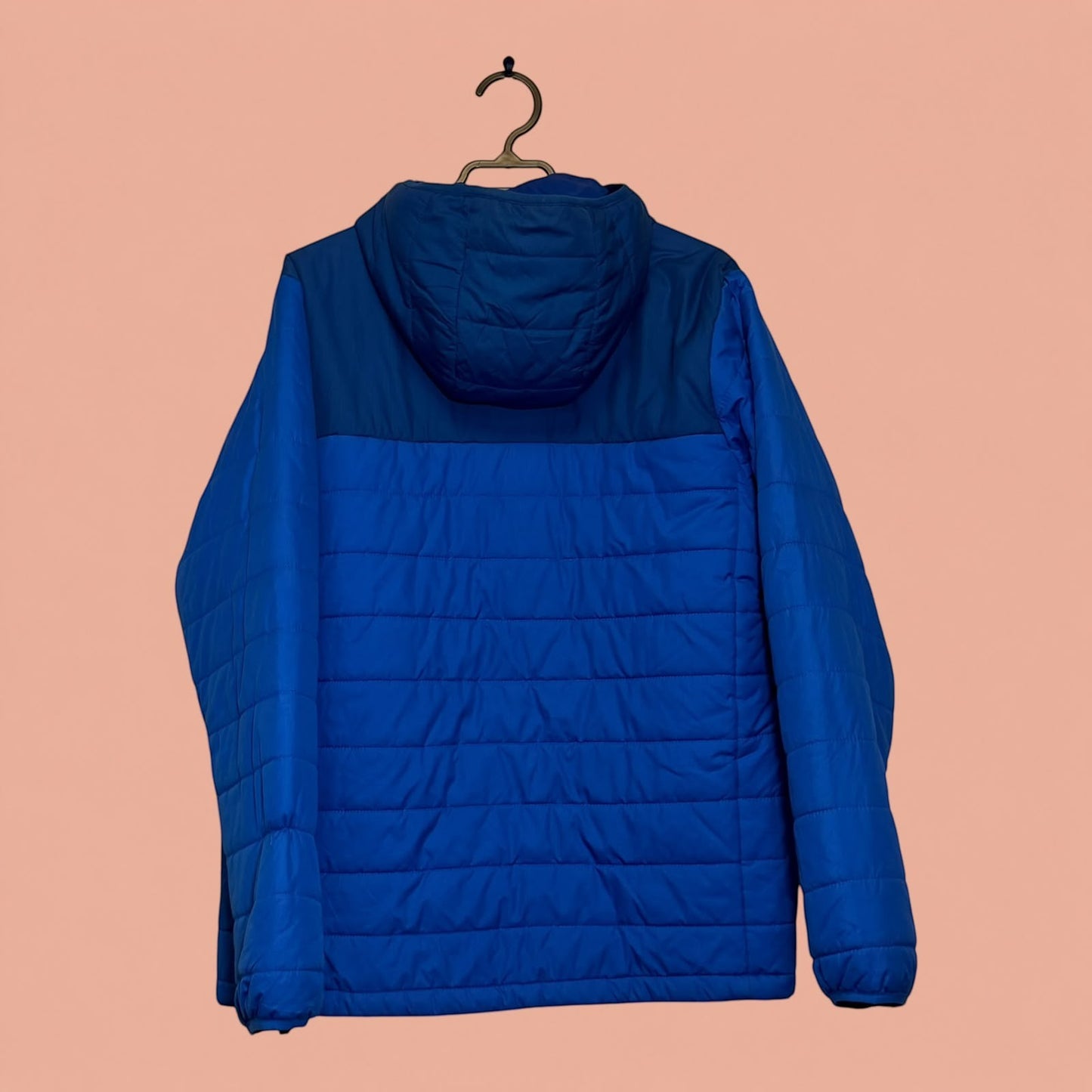 Chaqueta acolchada azul con capucha de Tuclosetrenovado.cl, diseño ligero para hombre, vista trasera.