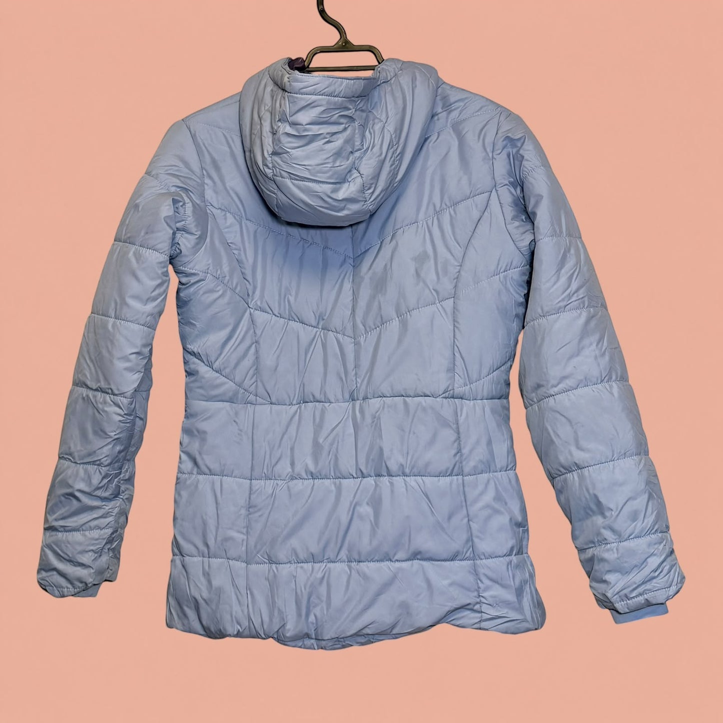 Chaqueta acolchada azul claro con capucha de Tuclosetrenovado.cl, vista trasera de prenda de segunda mano.