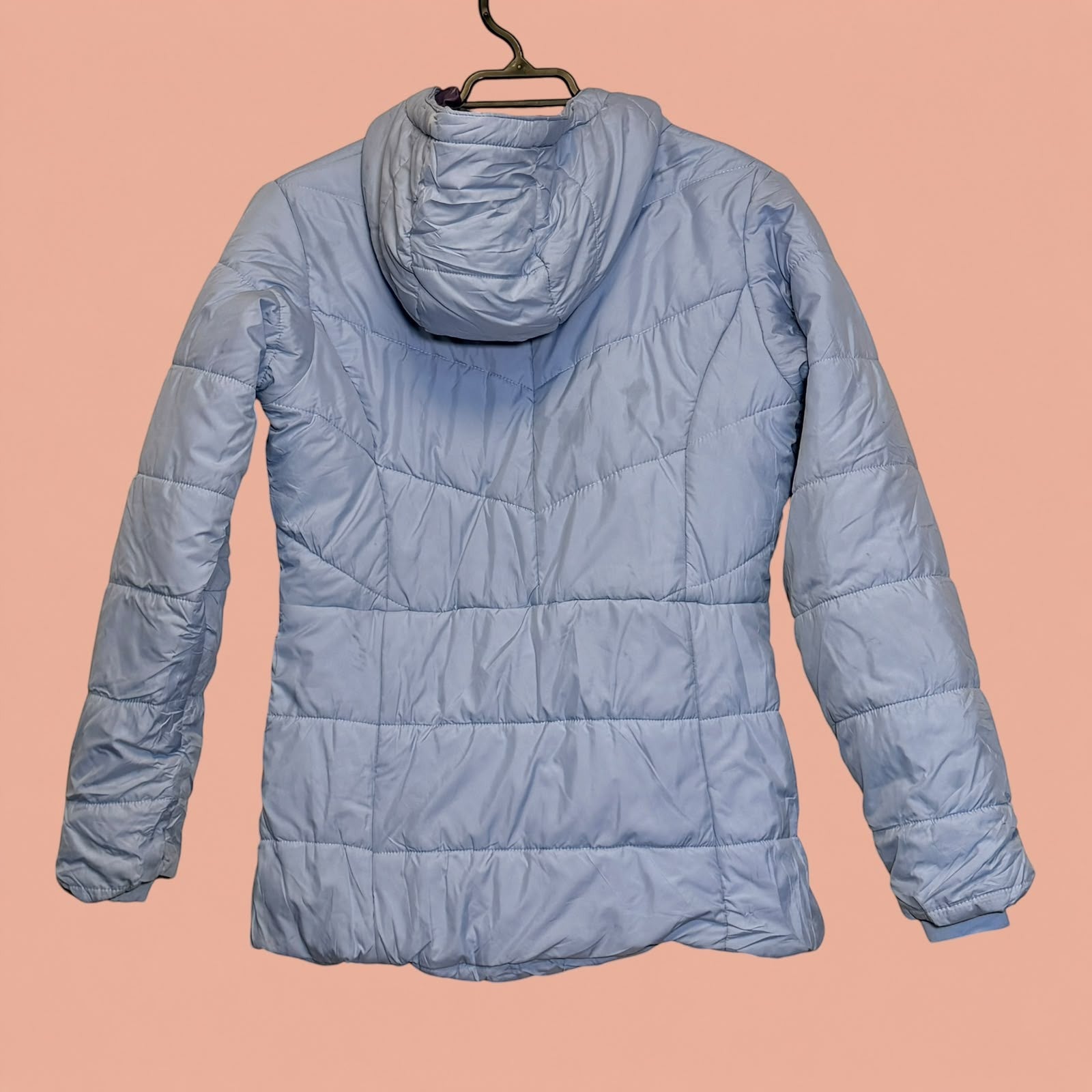 Chaqueta acolchada azul claro con capucha de Tuclosetrenovado.cl, vista trasera de prenda de segunda mano.