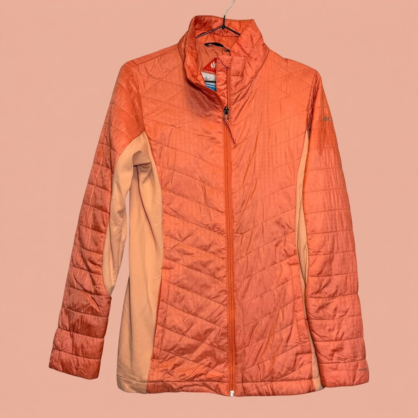 Chaqueta acolchada Columbia de Tuclosetrenovado.cl en color coral con cierre frontal y paneles laterales suaves.