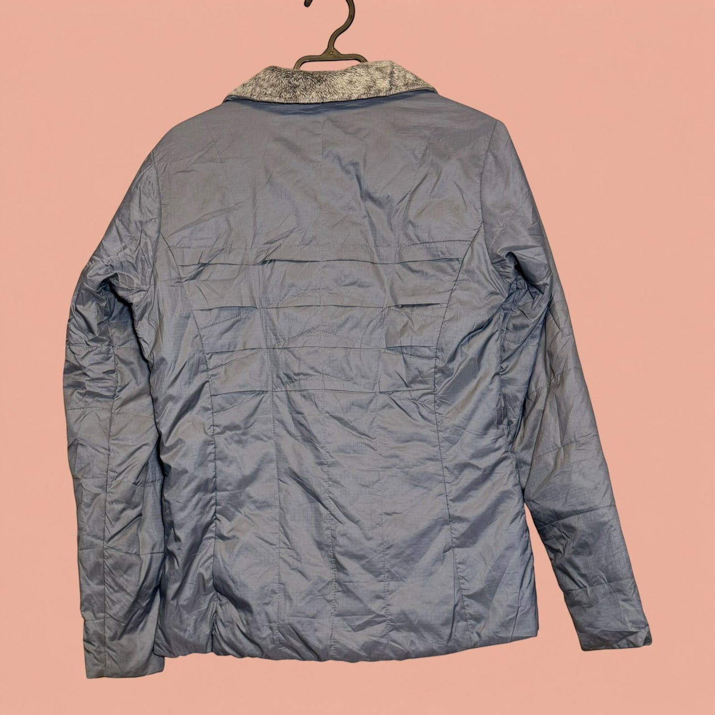Chaqueta acolchada azul de Tuclosetrenovado.cl con cuello de piel sintética gris, vista trasera