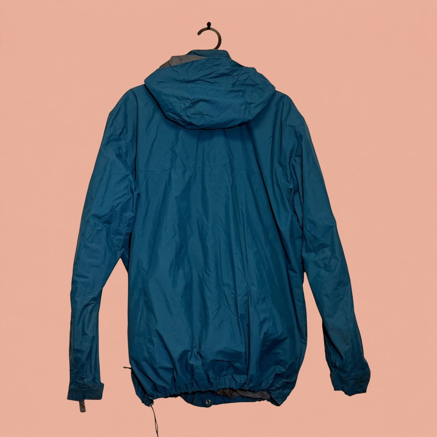 Chaqueta impermeable azul con capucha de Tuclosetrenovado.cl, vista trasera de prenda de hombre de segunda mano.