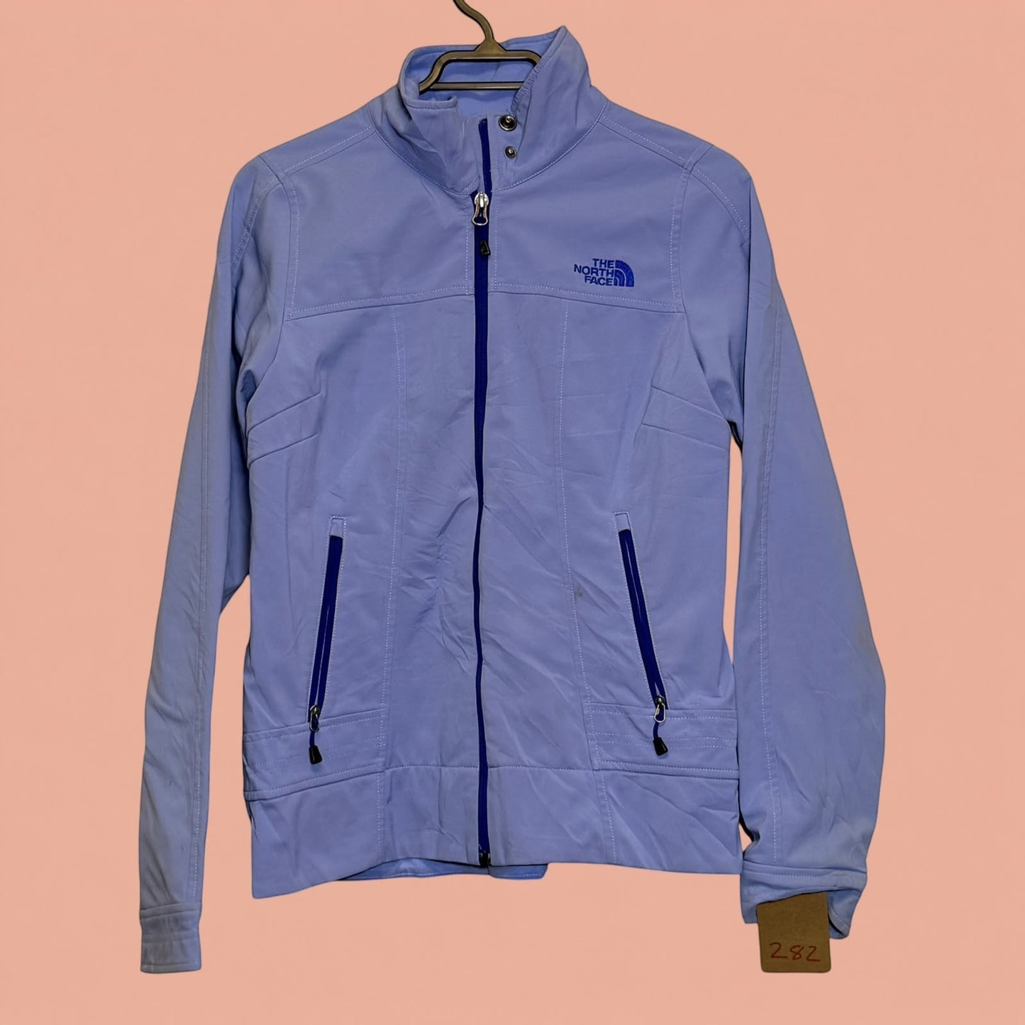 Chaqueta softshell azul claro The North Face de Tuclosetrenovado.cl con cierre frontal y bolsillos laterales
