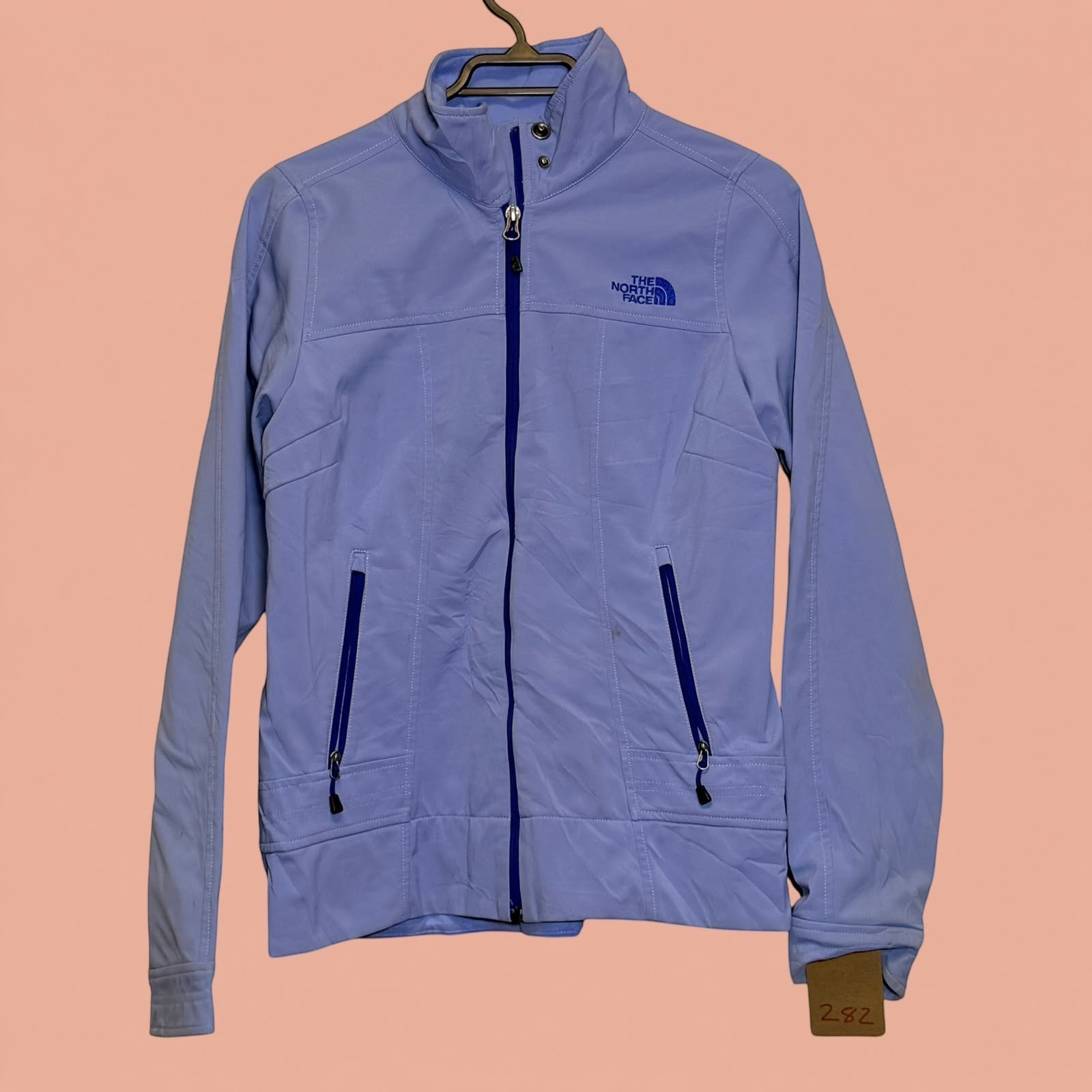 Chaqueta softshell azul claro The North Face de Tuclosetrenovado.cl con cierre frontal y bolsillos laterales