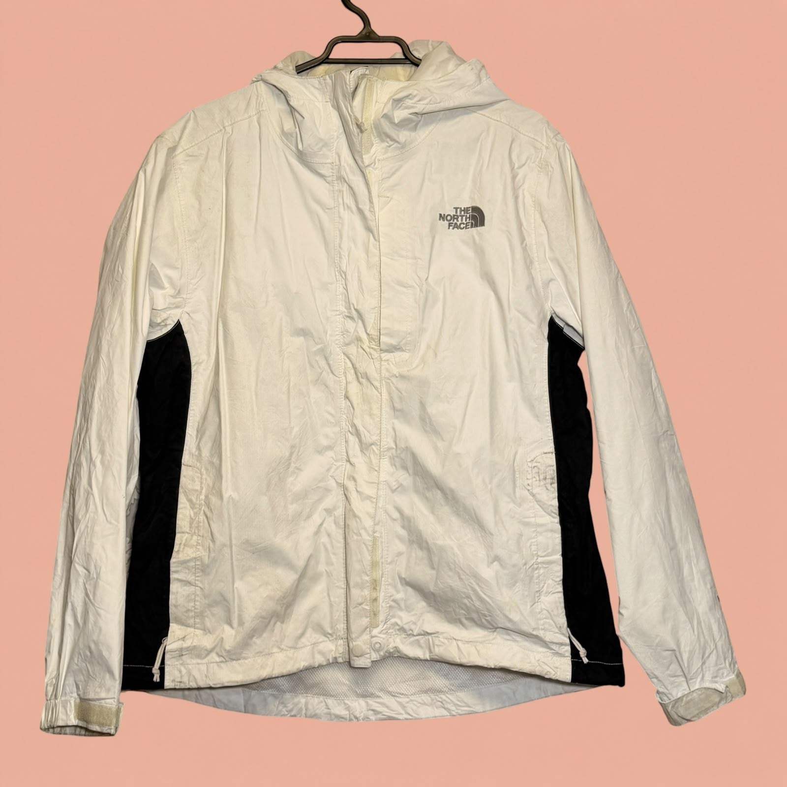 Chaqueta cortavientos blanca y negra The North Face de Tuclosetrenovado.cl con capucha y cierre frontal