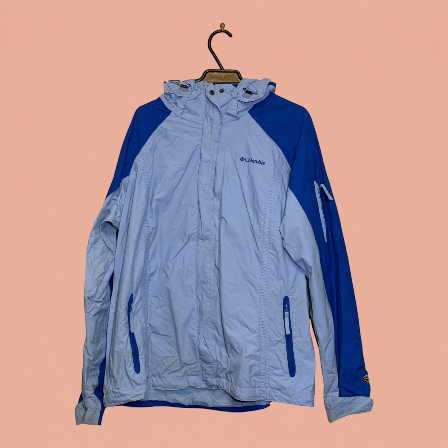 Chaqueta impermeable Columbia de Tuclosetrenovado.cl en color azul claro y oscuro con capucha y cierre frontal