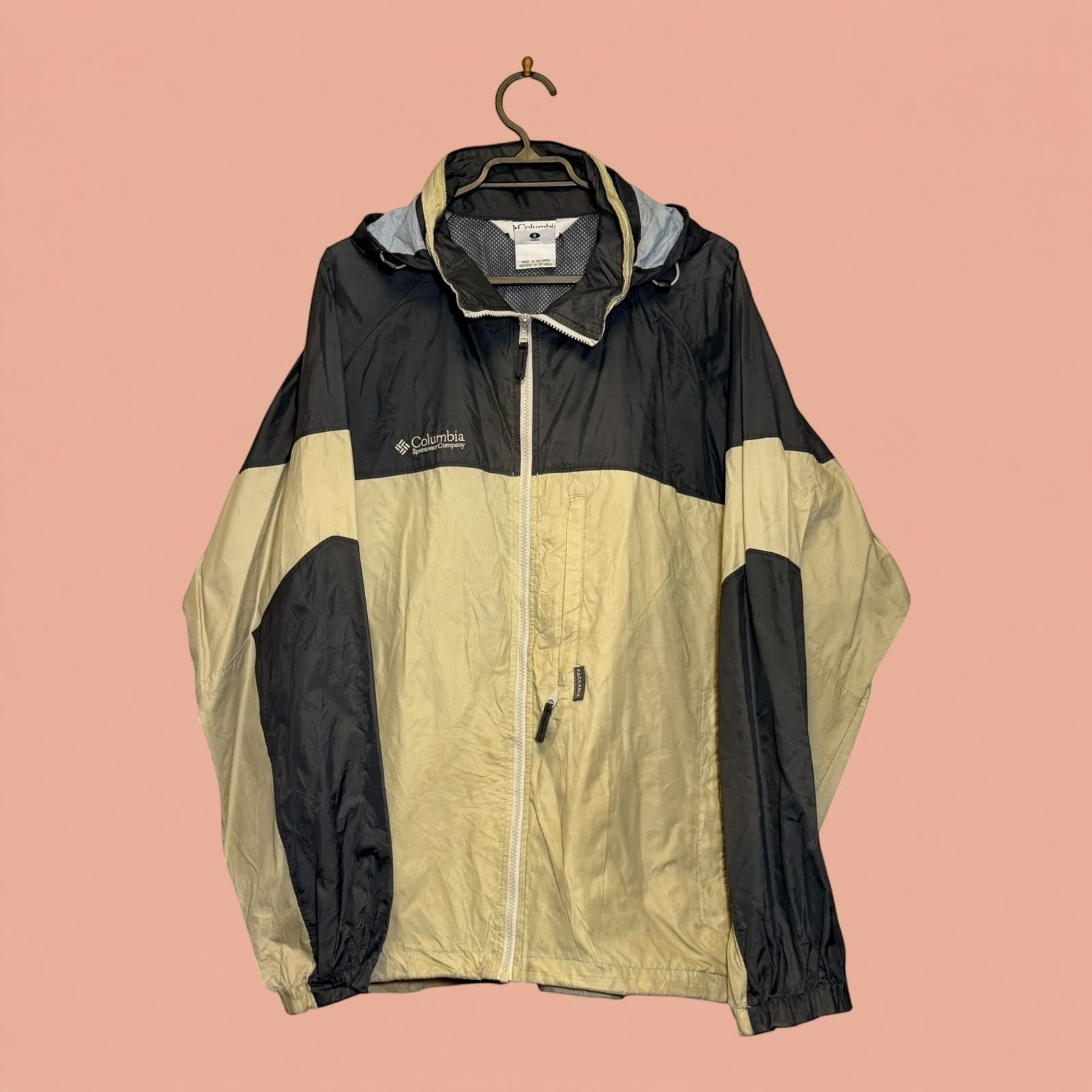 Chaqueta cortavientos Columbia de Tuclosetrenovado.cl en color negro y beige con cierre frontal y capucha