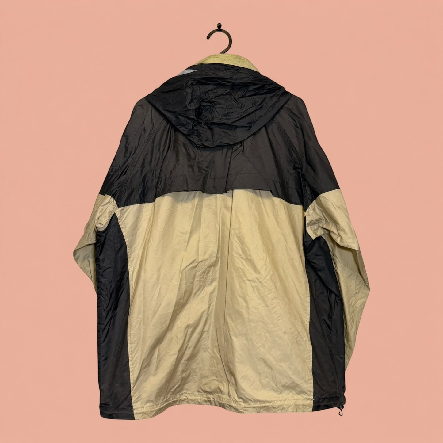 Chaqueta cortavientos Tuclosetrenovado.cl de hombre en color beige y negro con capucha, vista trasera.