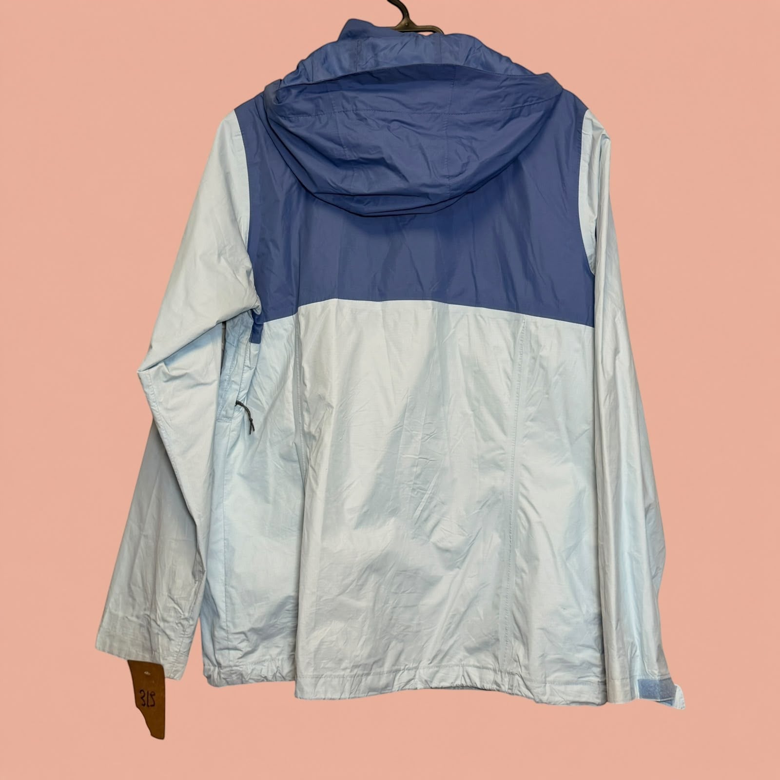 Chaqueta cortavientos Tuclosetrenovado.cl bicolor en azul y gris claro con capucha, vista trasera
