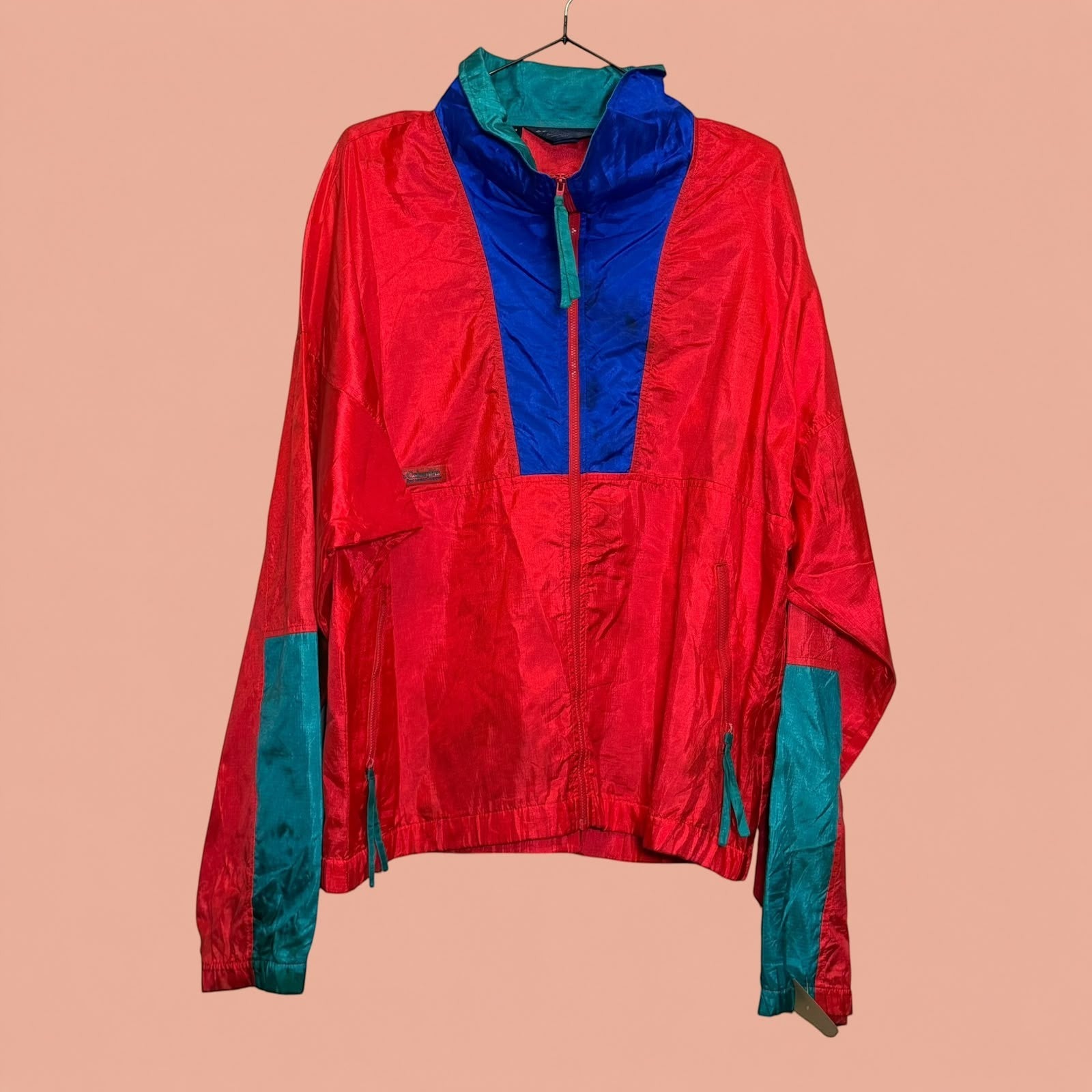 Chaqueta cortavientos vintage Tuclosetrenovado.cl roja con detalles en azul y verde, estilo deportivo de hombre.