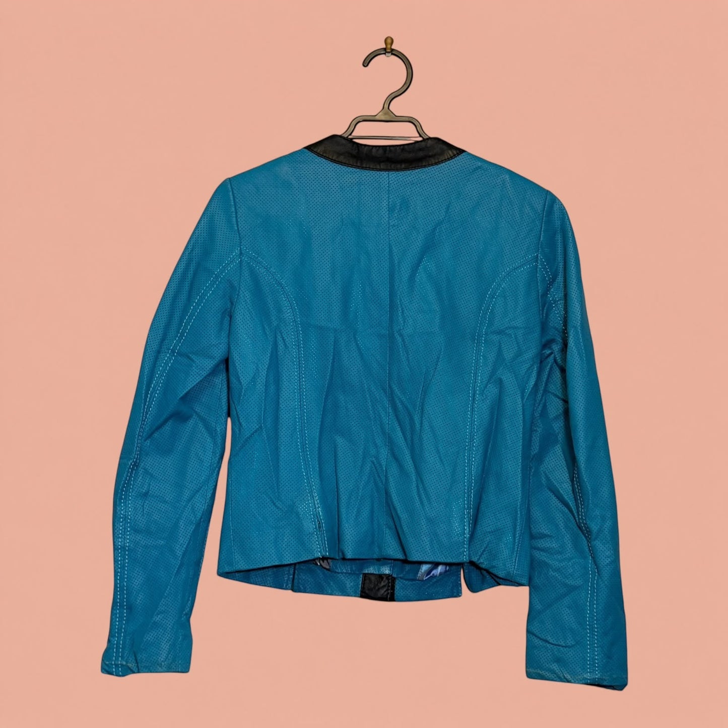 Chaqueta de eco cuero azul con textura perforada y cuello negro de Tuclosetrenovado.cl, vista trasera.