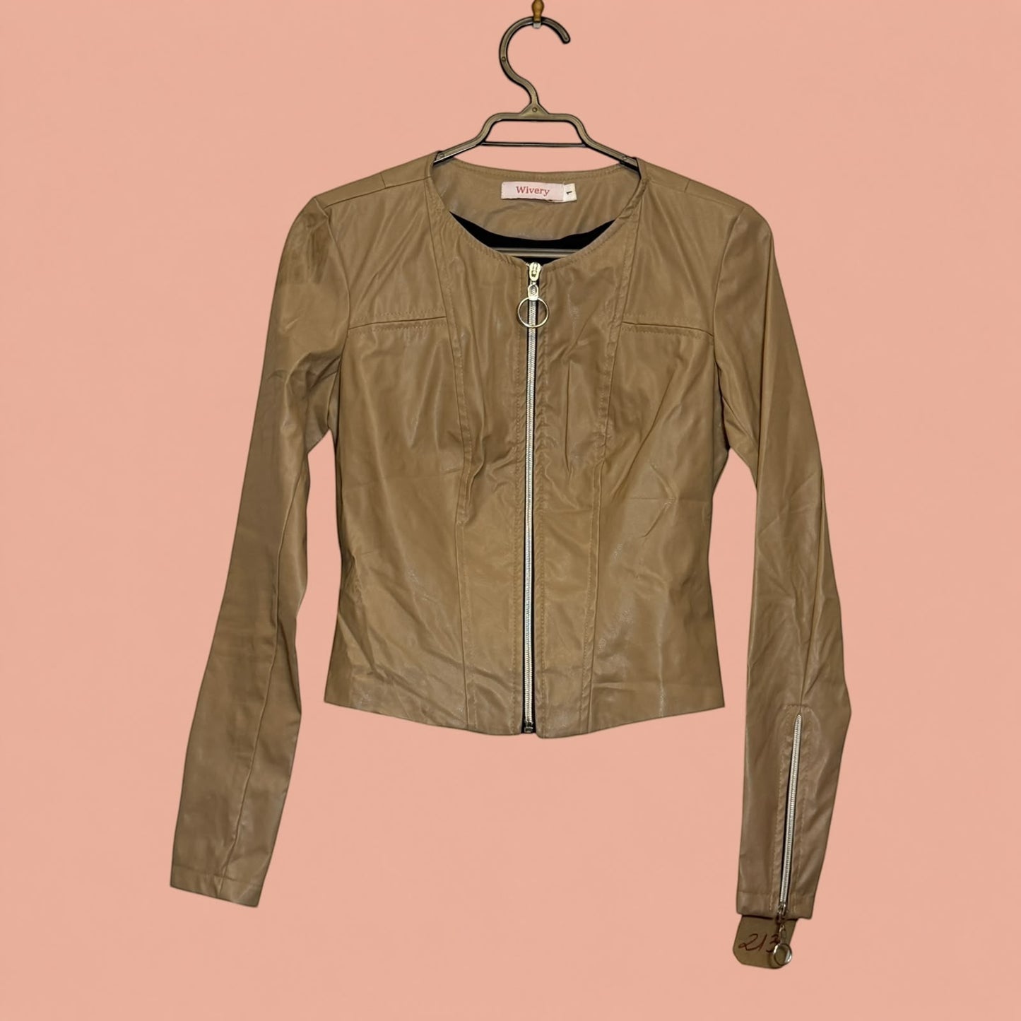 Chaqueta de eco cuero color beige de Tuclosetrenovado.cl con cierre frontal y cremalleras en las mangas