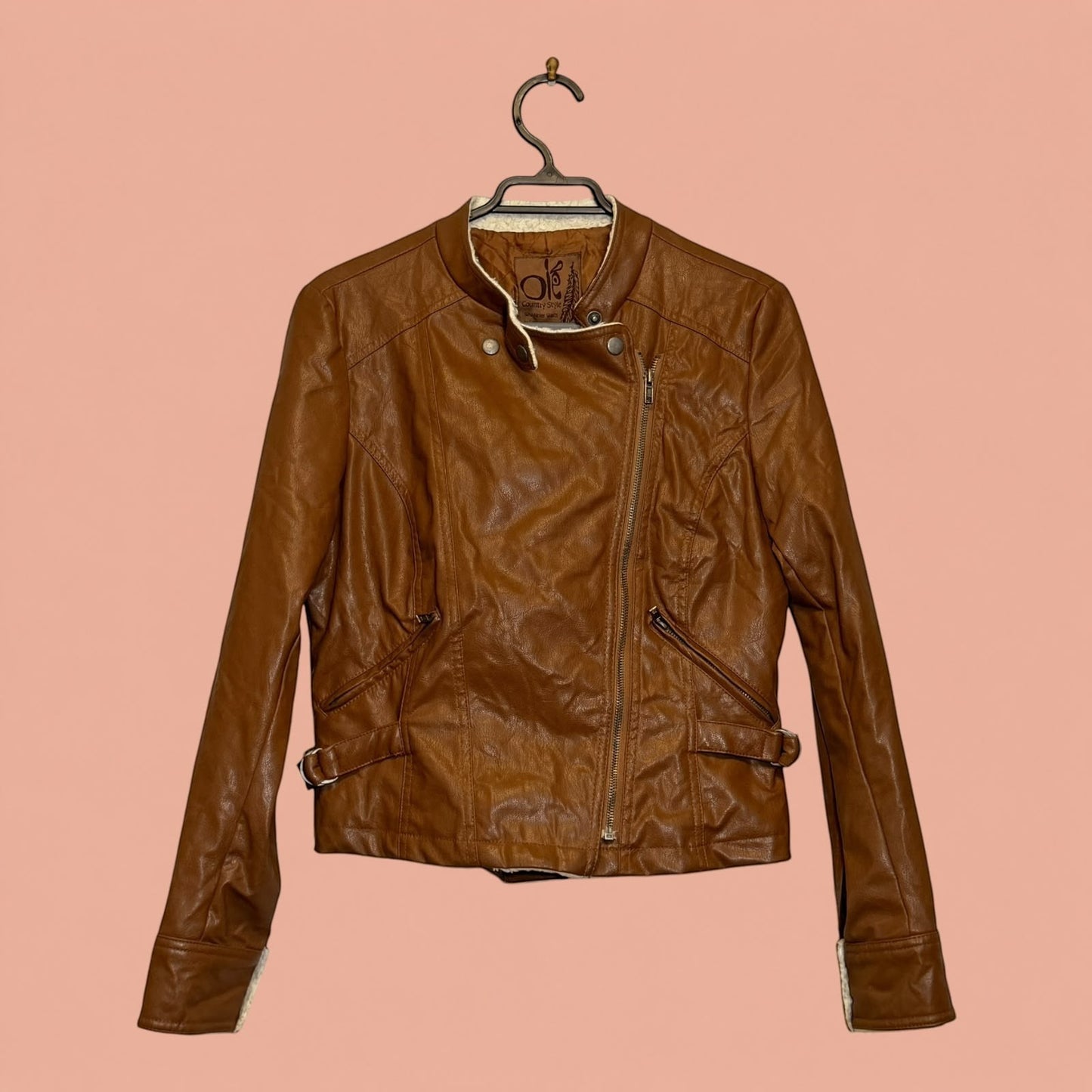 Chaqueta de eco cuero color café de Tuclosetrenovado.cl con cierre diagonal y forro interior de chiporro