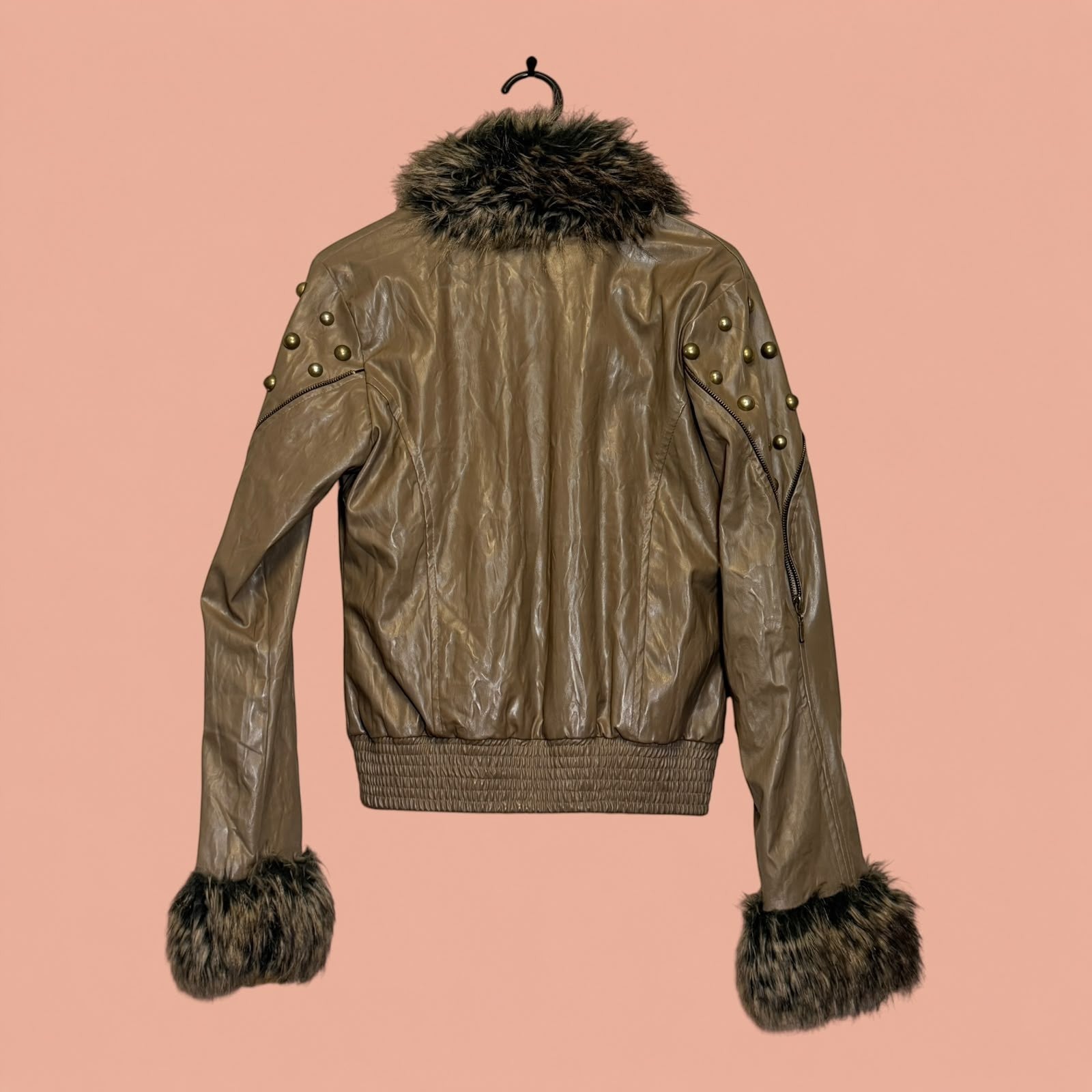 Chaqueta de eco cuero marrón de Tuclosetrenovado.cl con detalles de tachuelas doradas y bordes de piel sintética