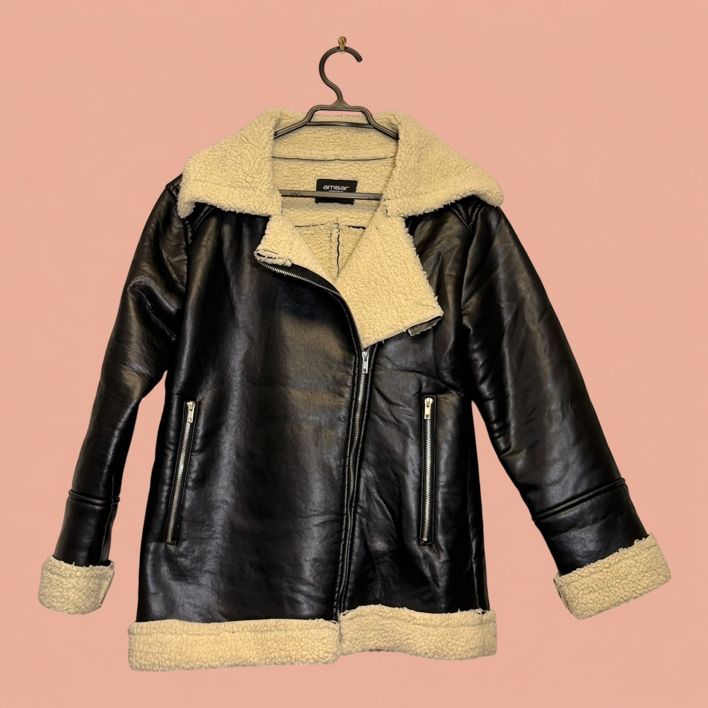 Chaqueta de eco cuero negra con forro de chiporro beige de Tuclosetrenovado.cl, estilo aviador con cierre frontal.