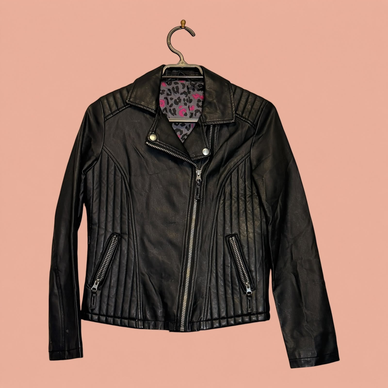 Chaqueta de eco cuero negra de segunda mano de Tuclosetrenovado.cl con cremalleras y forro estampado