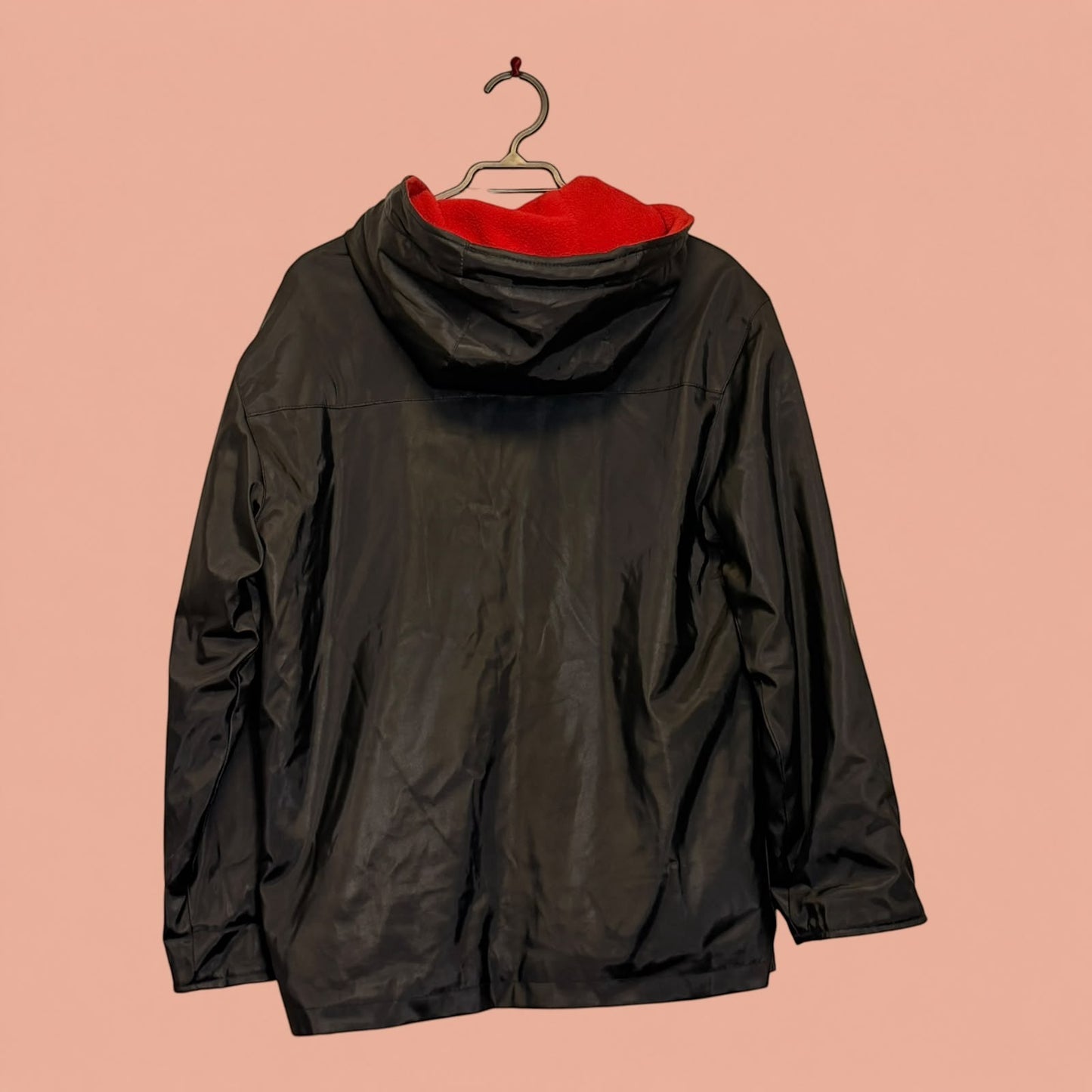 Chaqueta de eco cuero negra de Tuclosetrenovado.cl con capucha y forro interior de polar rojo, vista trasera.