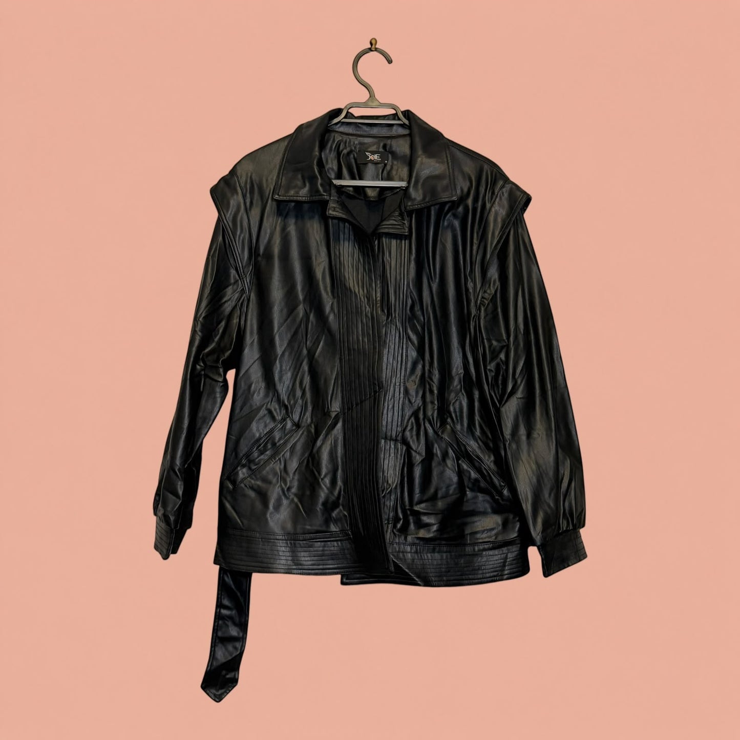 Chaqueta de eco cuero negra de segunda mano de Tuclosetrenovado.cl con cuello clásico y cinturón integrado
