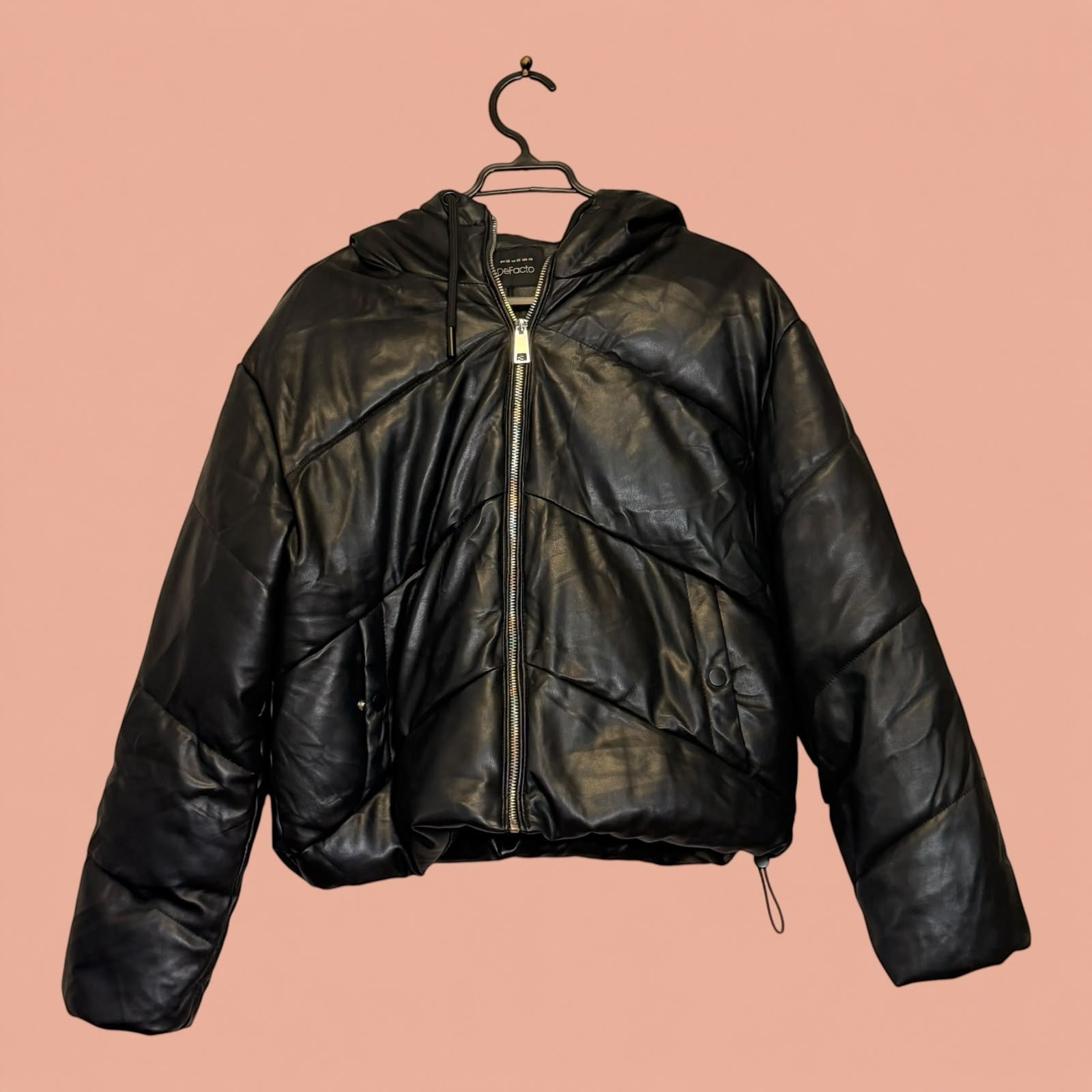 Chaqueta acolchada de eco cuero negro con capucha de Tuclosetrenovado.cl, estilo moderno y cierre frontal