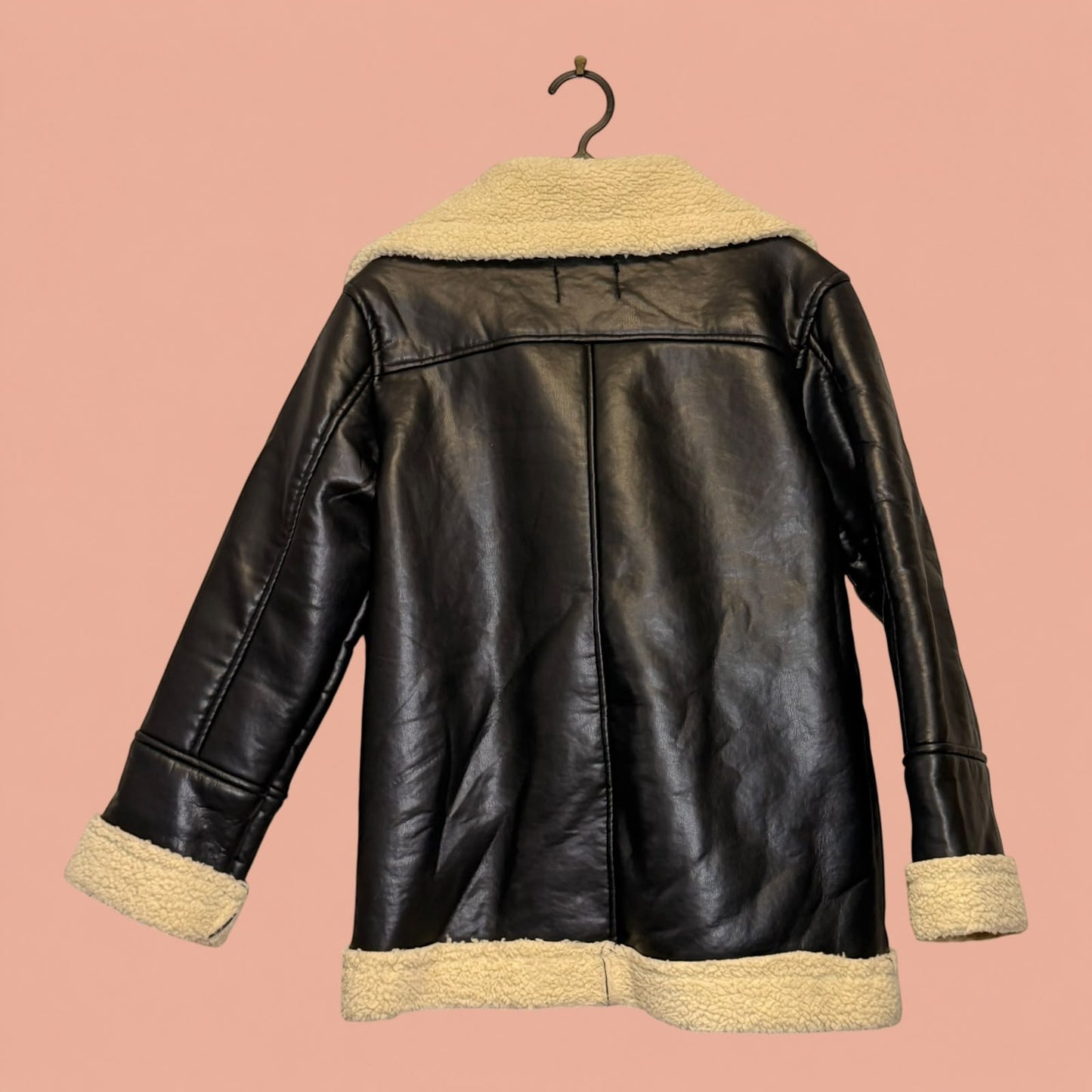 Chaqueta de eco cuero negra con forro de chiporro beige de Tuclosetrenovado.cl, estilo aviador de segunda mano.