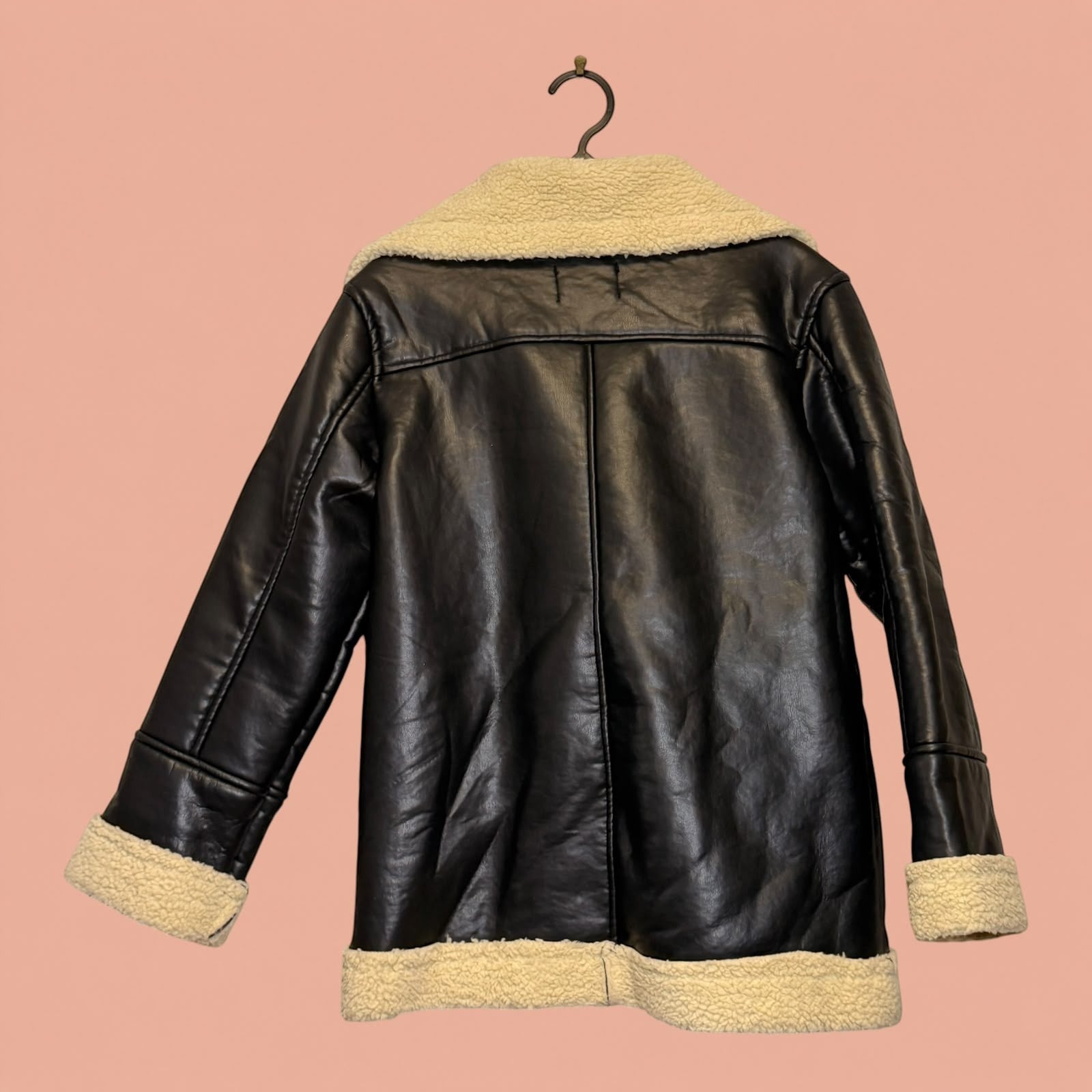 Chaqueta de eco cuero negra con forro de chiporro beige de Tuclosetrenovado.cl, estilo aviador de segunda mano.