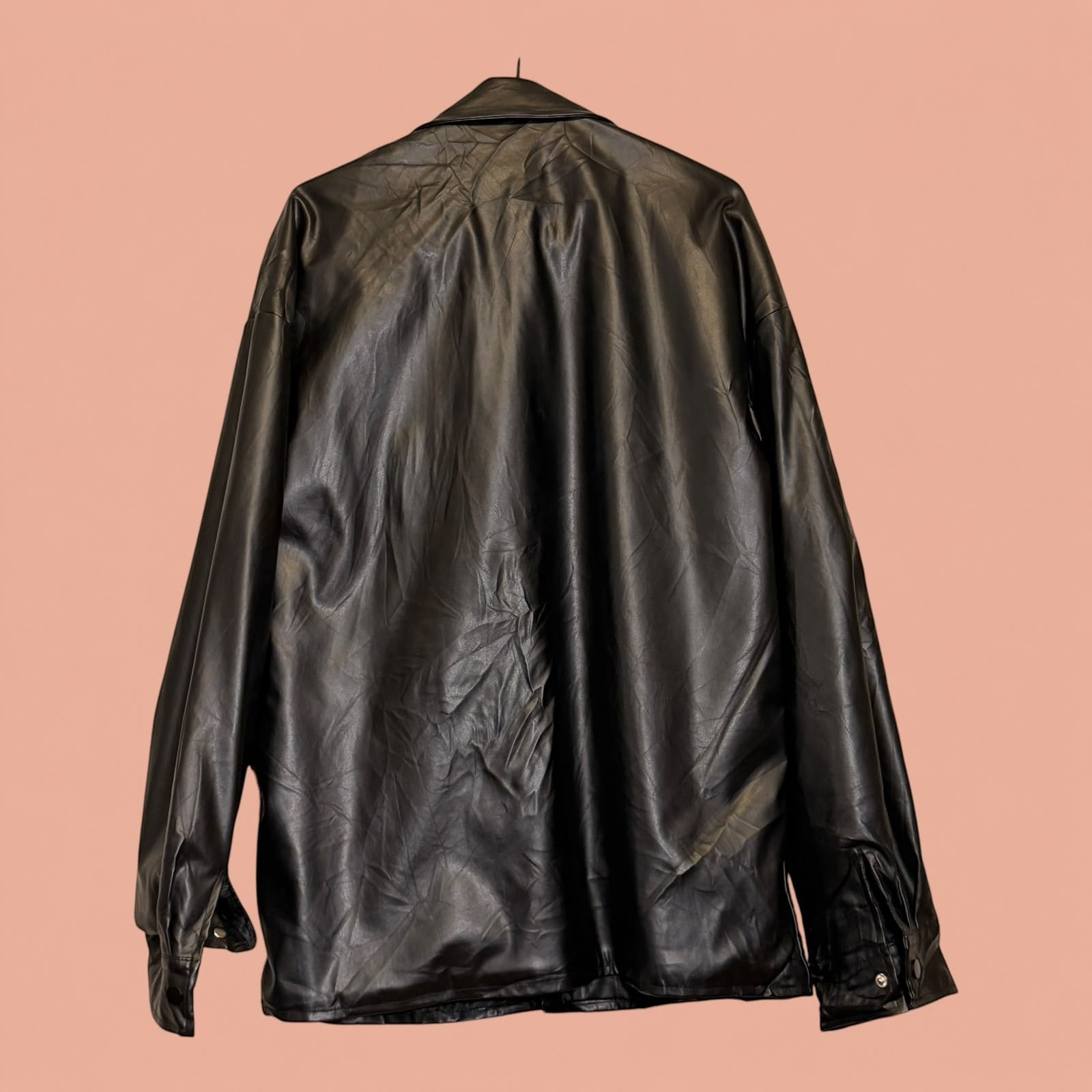 Chaqueta de eco cuero negra de segunda mano de Tuclosetrenovado.cl vista trasera con acabado brillante