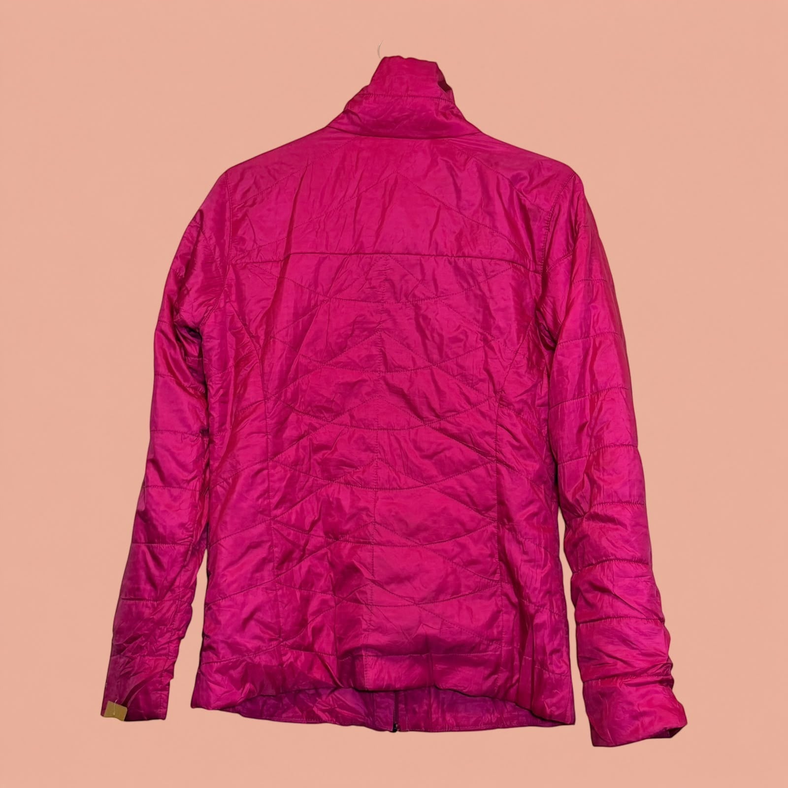 Chaqueta acolchada fucsia de segunda mano Tuclosetrenovado.cl con diseño de costuras curvas en la espalda