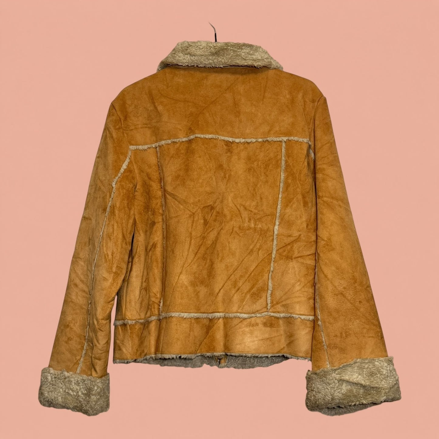 Chaqueta gamulan Tuclosetrenovado.cl de color camel con forro de piel sintética y costuras visibles, vista trasera.