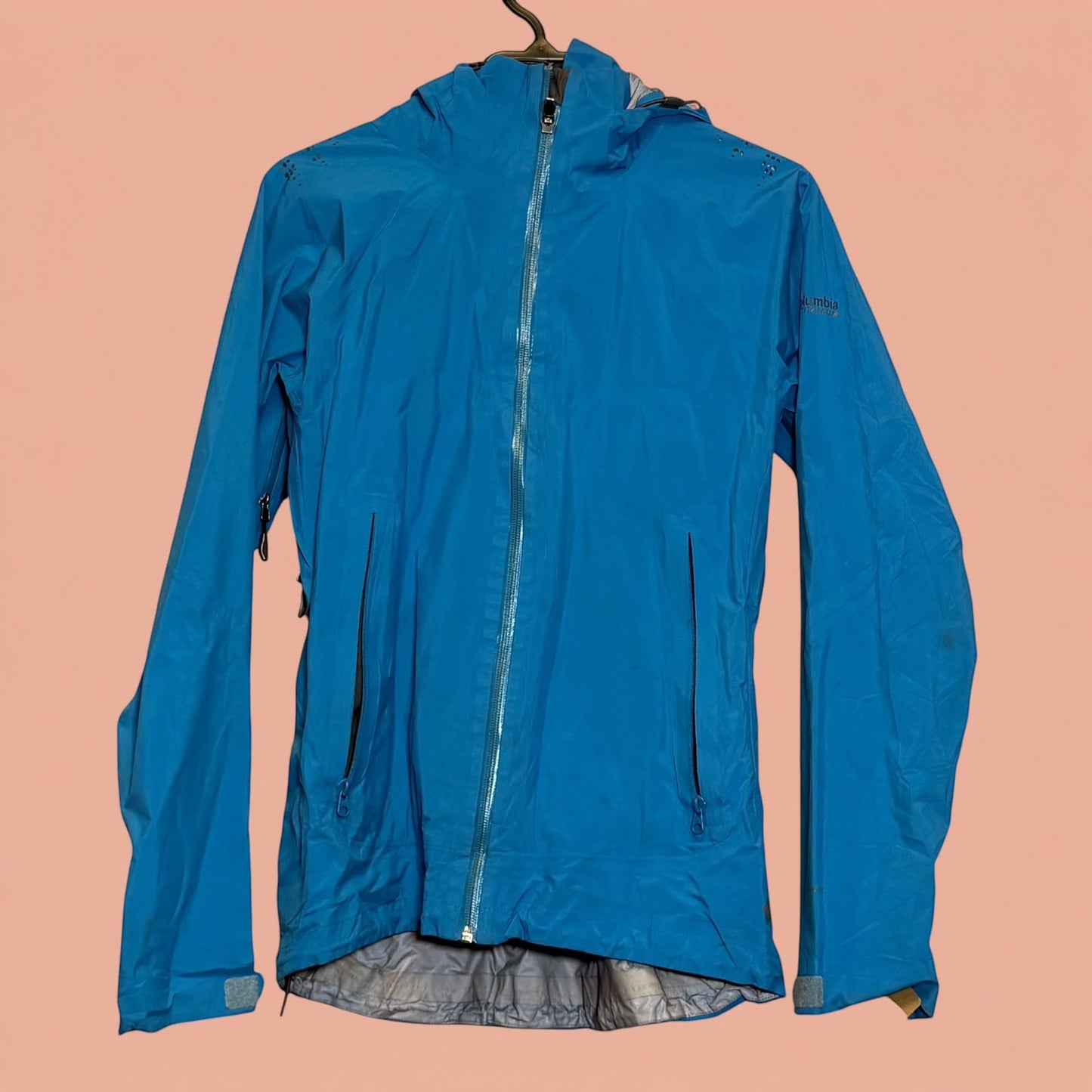 Chaqueta impermeable azul Columbia de Tuclosetrenovado.cl con capucha y cierre frontal, ideal para senderismo.
