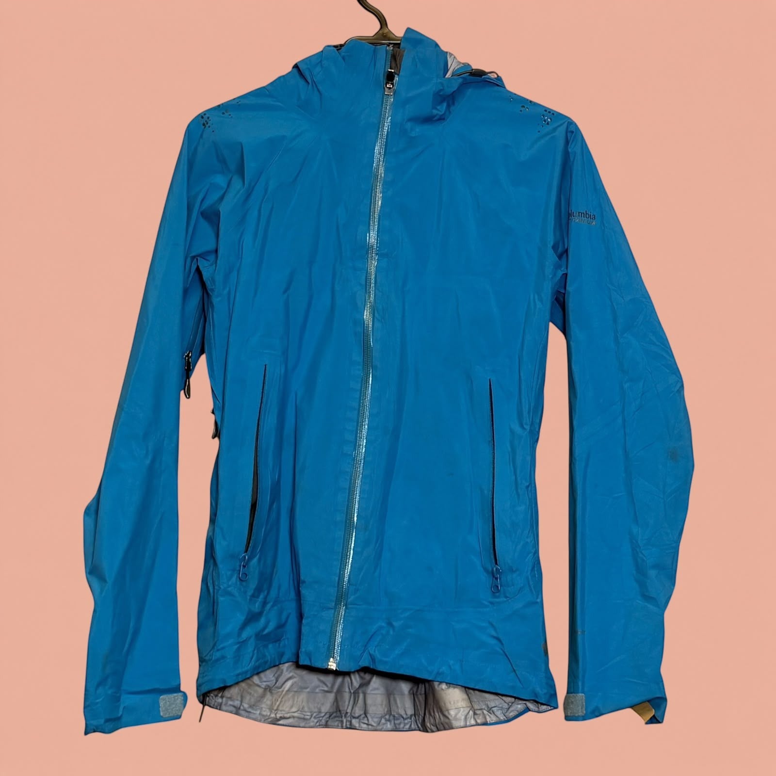 Chaqueta impermeable azul Columbia de Tuclosetrenovado.cl con capucha y cierre frontal, ideal para senderismo.
