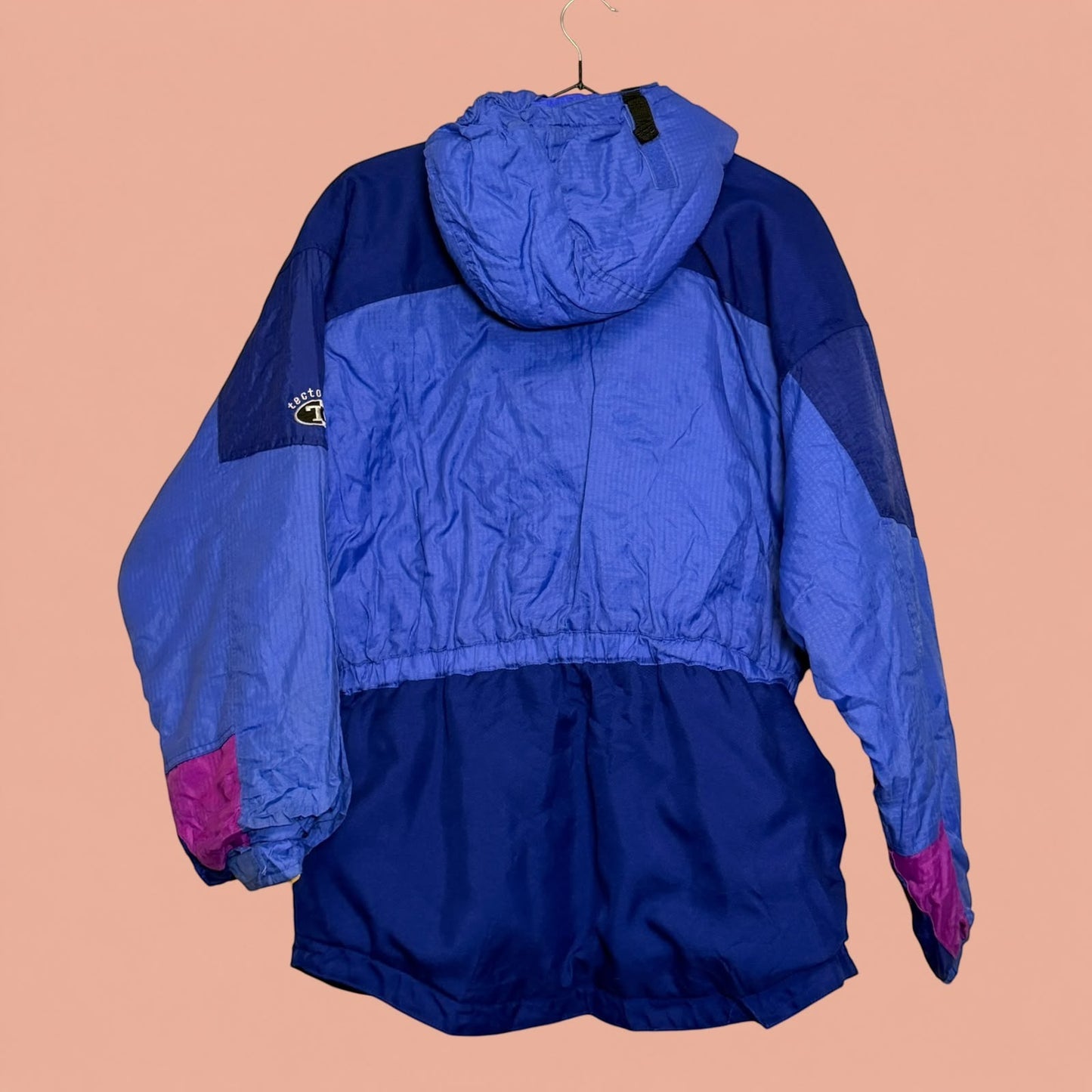 Chaqueta técnica de invierno Tuclosetrenovado.cl en tonos azul y morado con capucha y diseño acolchado