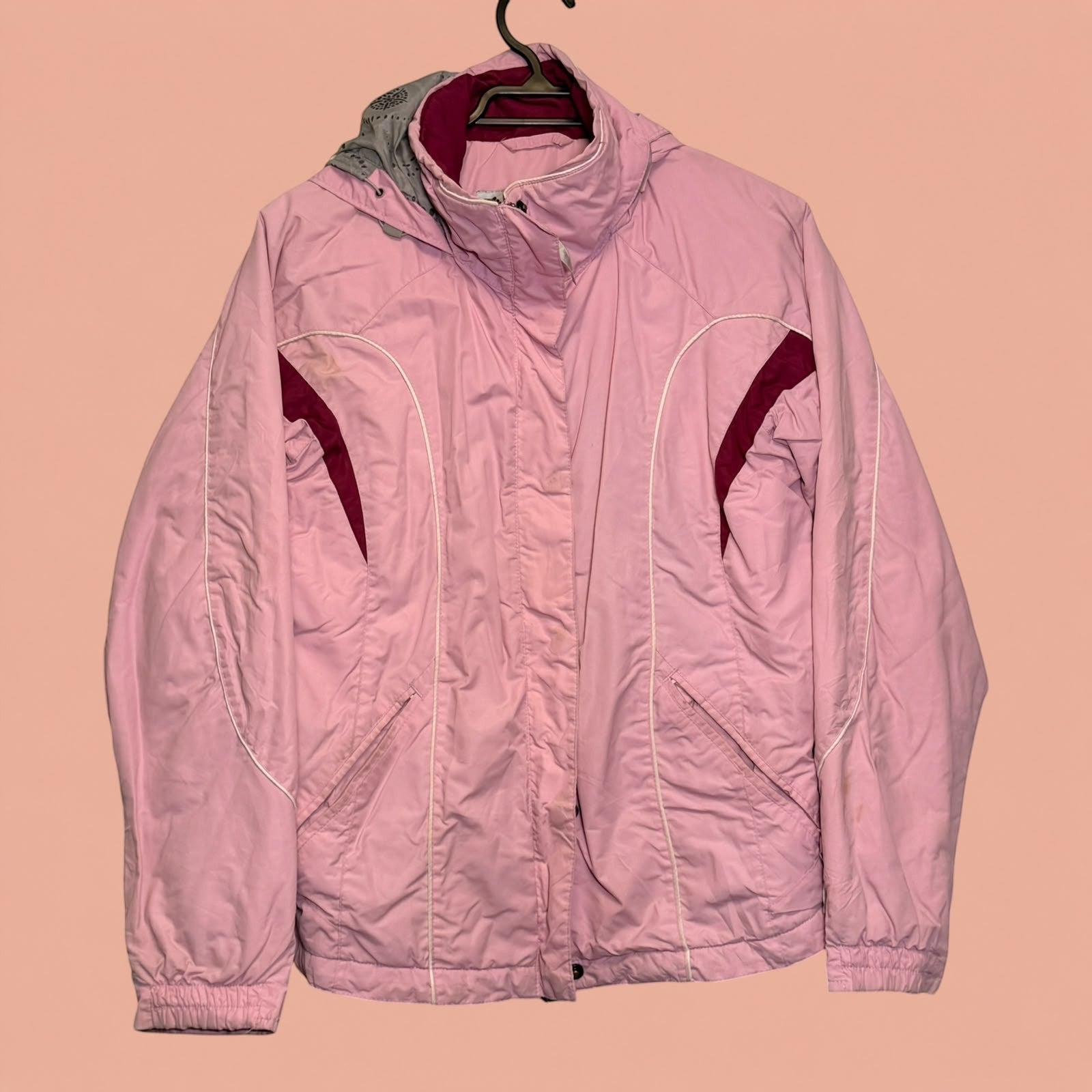 Chaqueta de invierno rosa Tuclosetrenovado.cl con capucha gris y detalles en burdeos, estilo deportivo de segunda mano.
