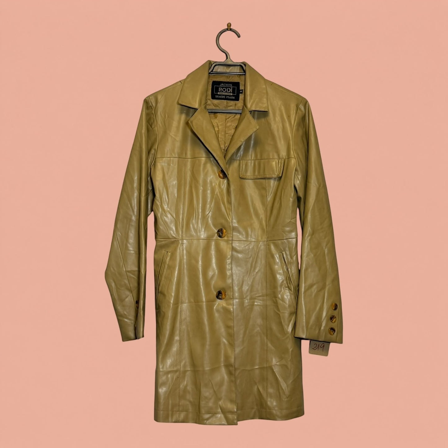 Chaqueta larga de eco cuero color beige de Tuclosetrenovado.cl con botones frontales y solapas clásicas