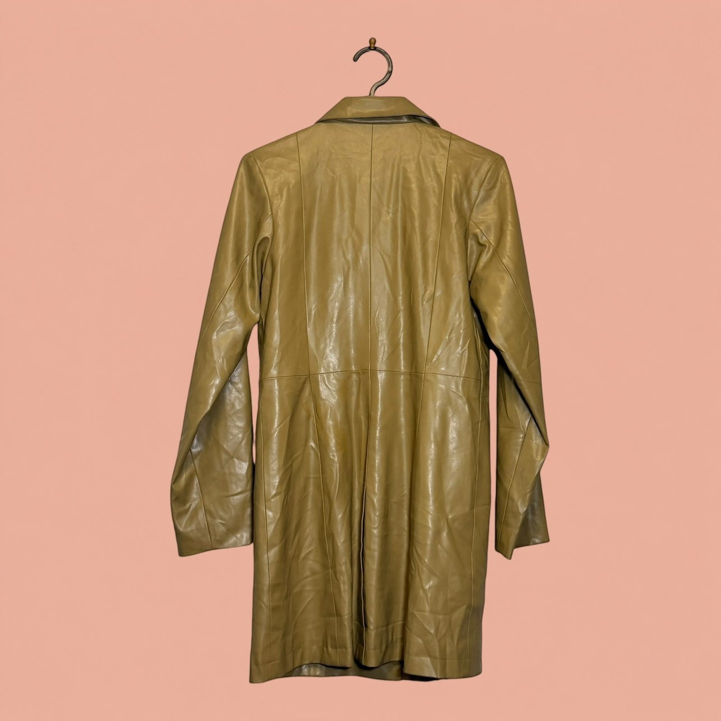 Chaqueta larga de eco cuero color beige de Tuclosetrenovado.cl vista trasera sobre fondo rosado
